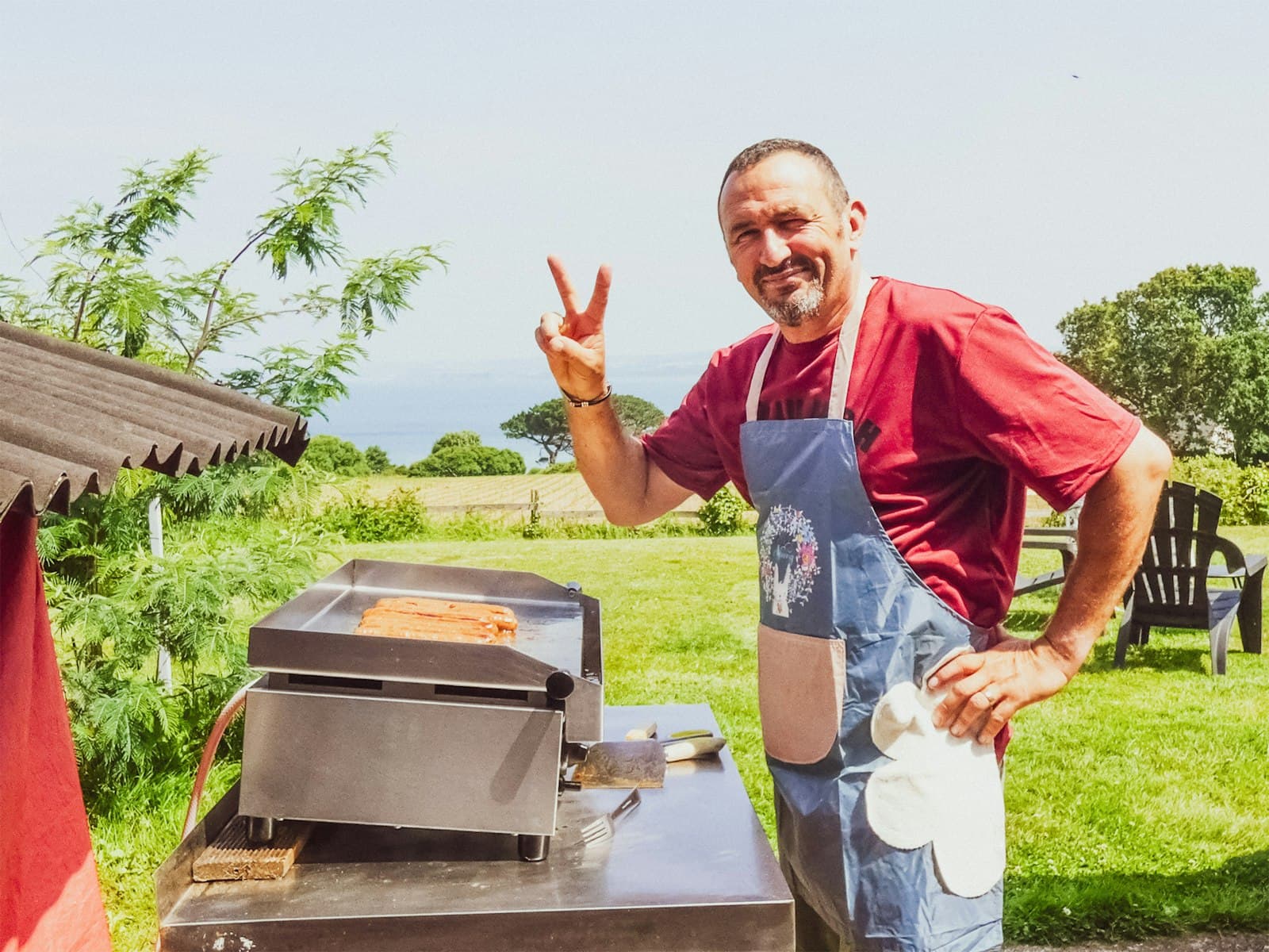 Douarnenez — Man grilling hot dogs and giving peace sign