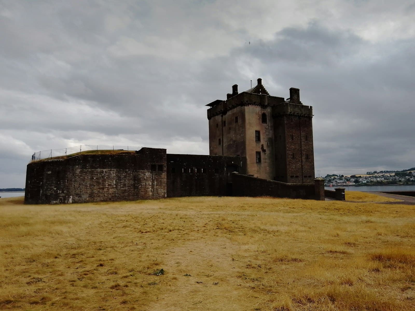 Dundee — A large castle sitting on top of a dry grass field