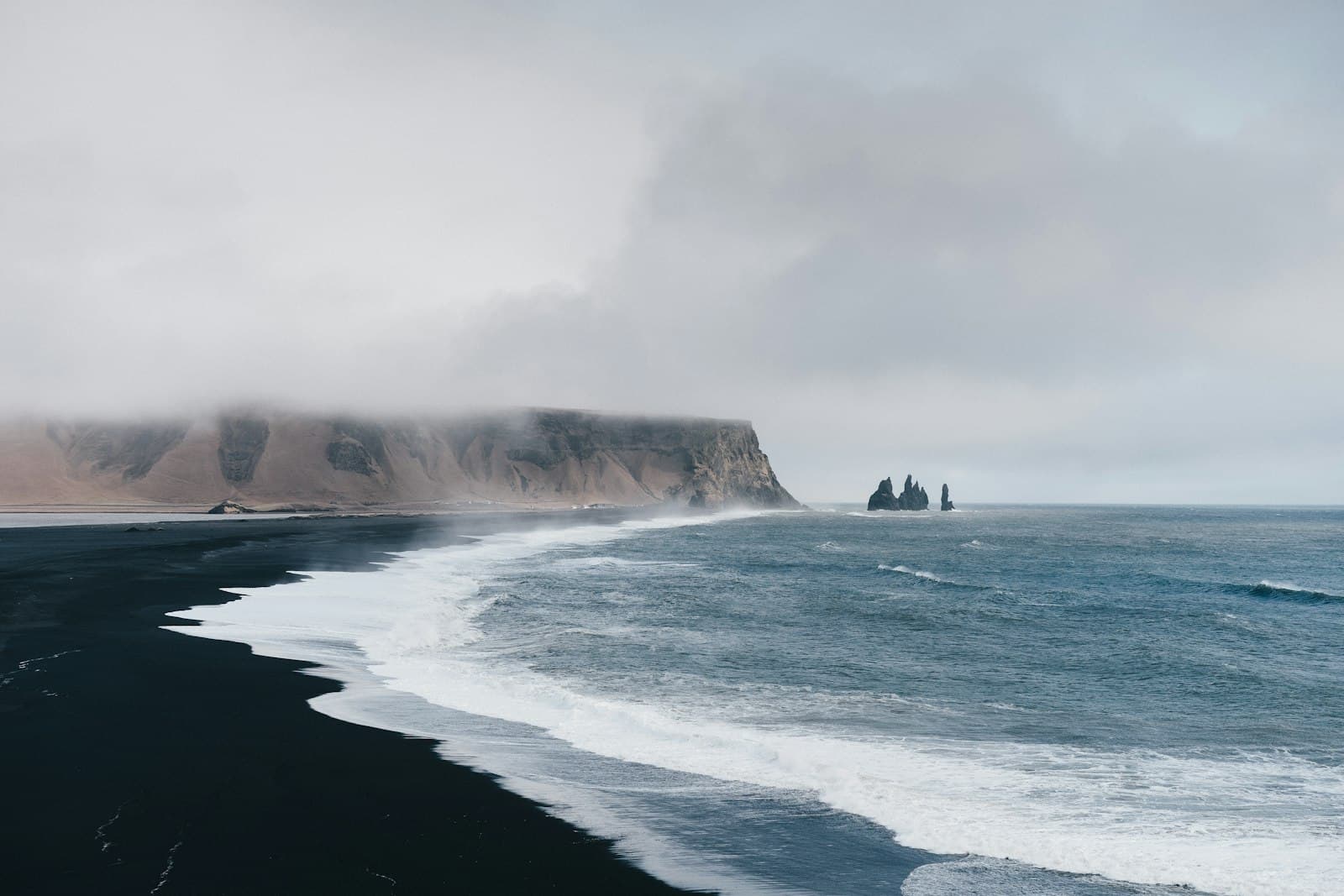 Egilsstaðir — black sand near body of water under the cloudy sky during daytime