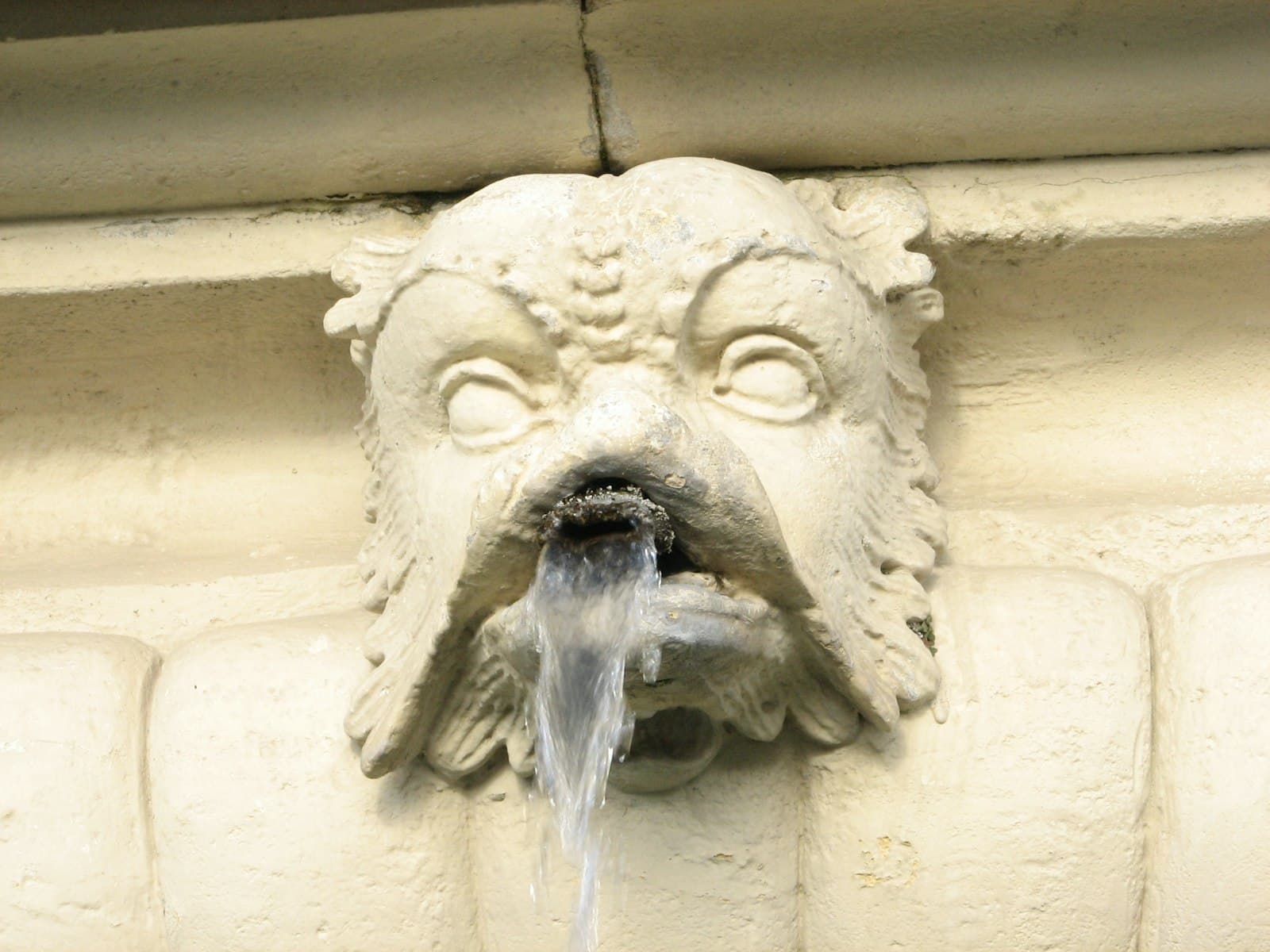 Eisenstadt — a water fountain with a face on the side of a building