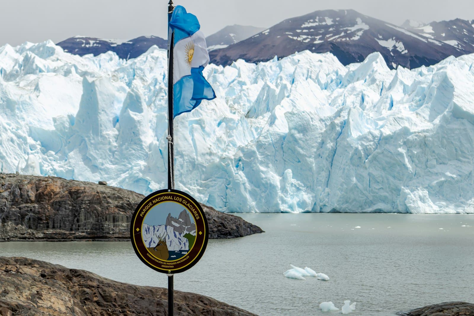 El Calafate — A flag pole in front of a glacier with mountains in the background