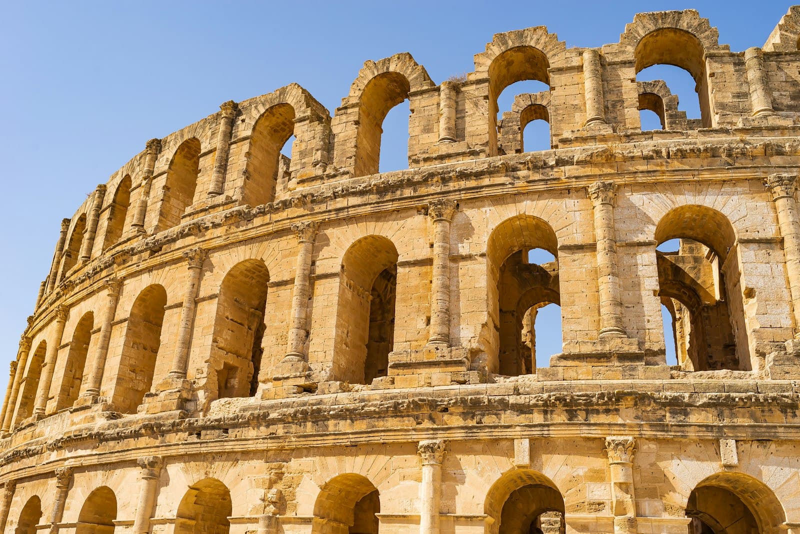 El Jem — a large stone building with El Djem in the background