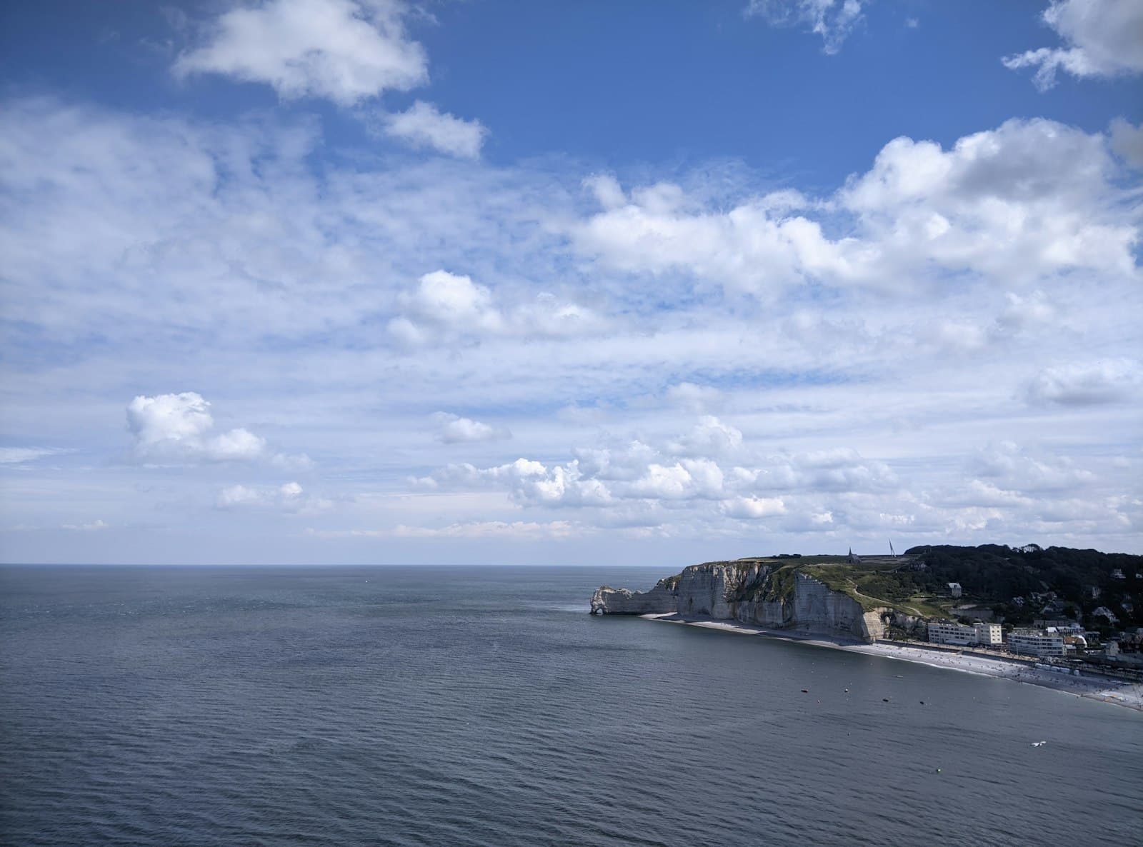 Falaise — a large body of water sitting under a cloudy blue sky
