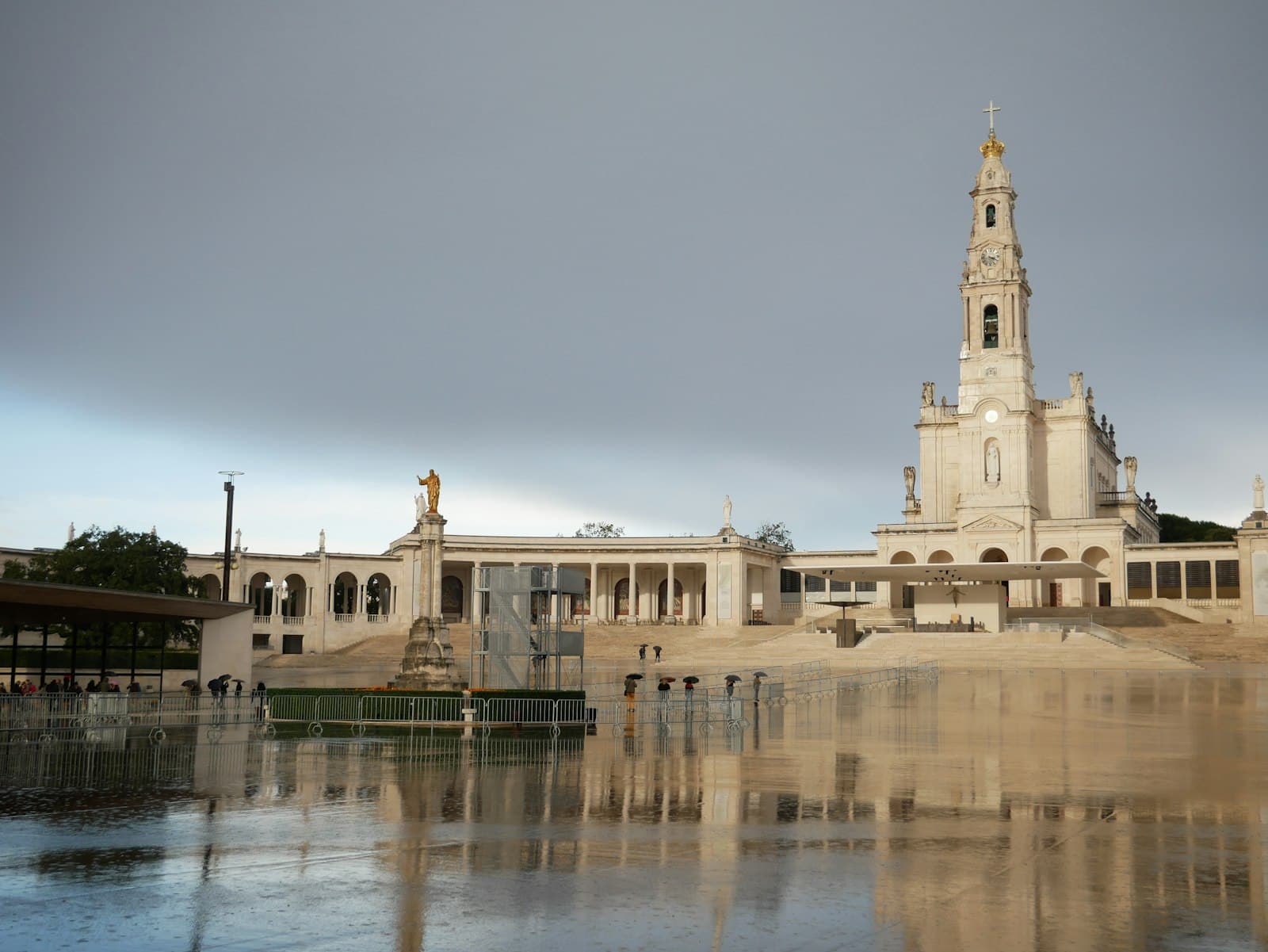 Fátima — a large building with a clock tower next to a body of water
