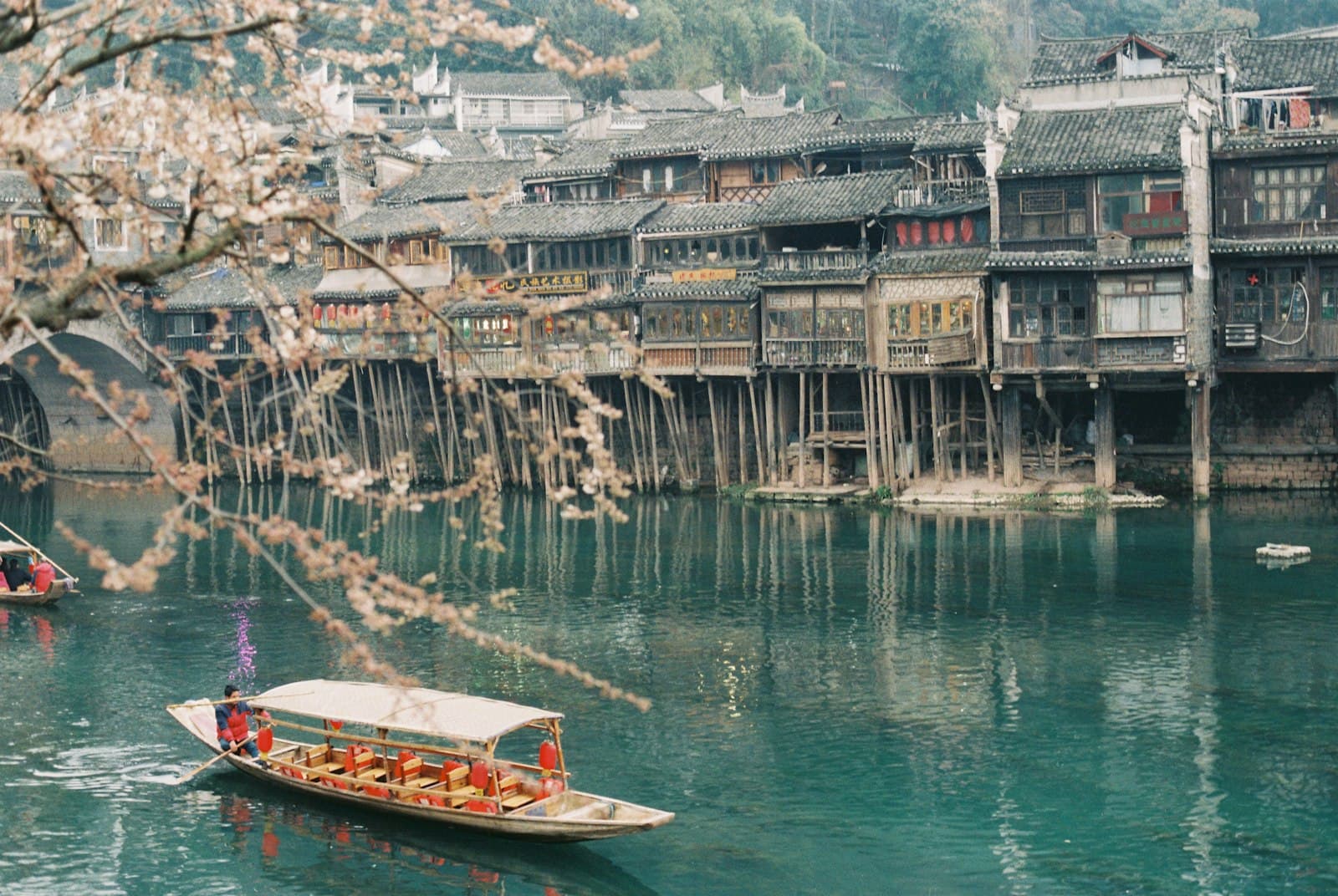 Fenghuang — brown boat on body of water near buildings