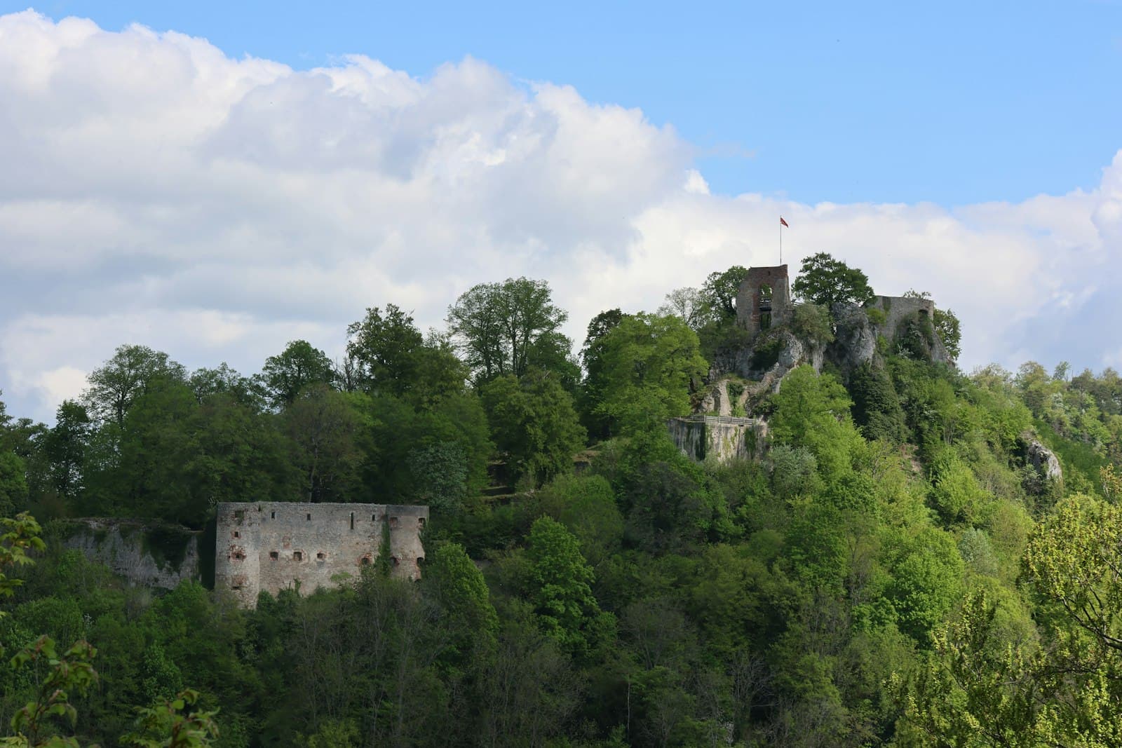 Ferrette — Ruins of a castle on a lush green hill.