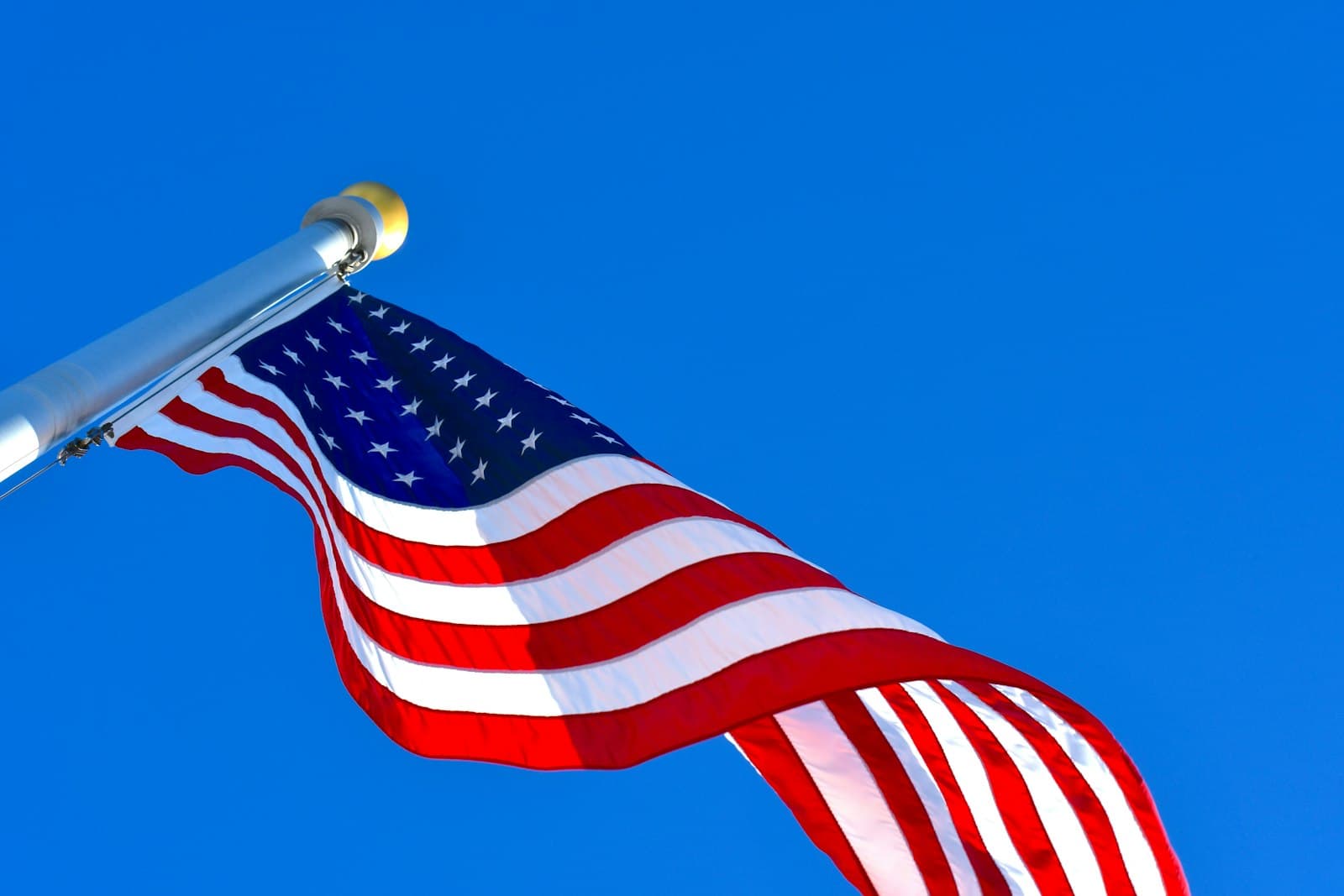 Flagstaff — us a flag under blue sky during daytime