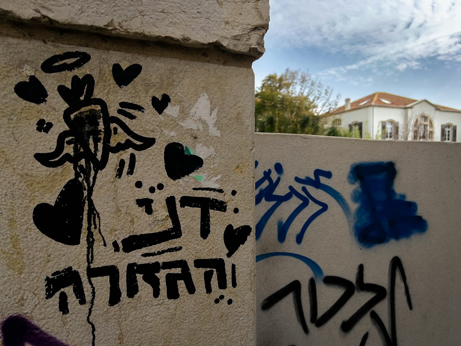 Florentin Street Art — a wall with some graffiti on it and a building in the background