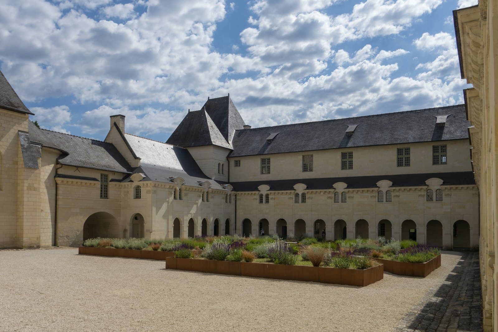 Fontevraud-l'Abbaye — a large building with a lot of plants in front of it