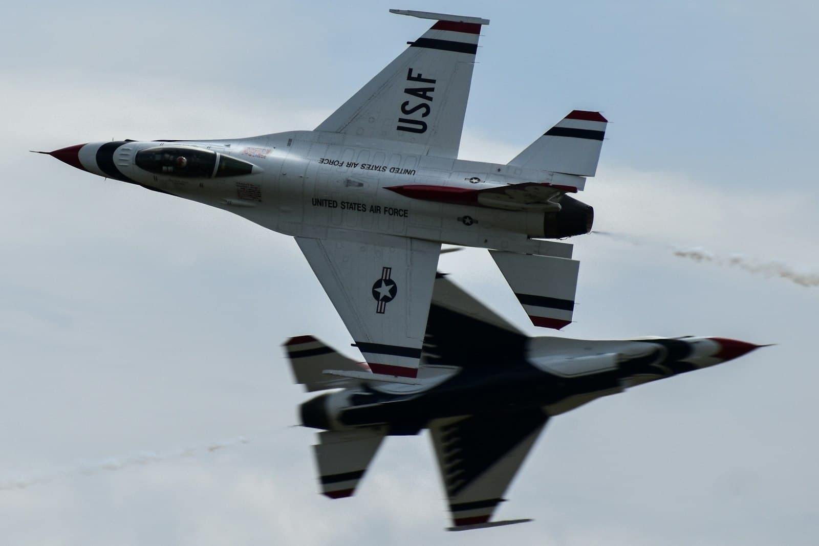 Fort Wayne — A fighter jet flying through a cloudy blue sky