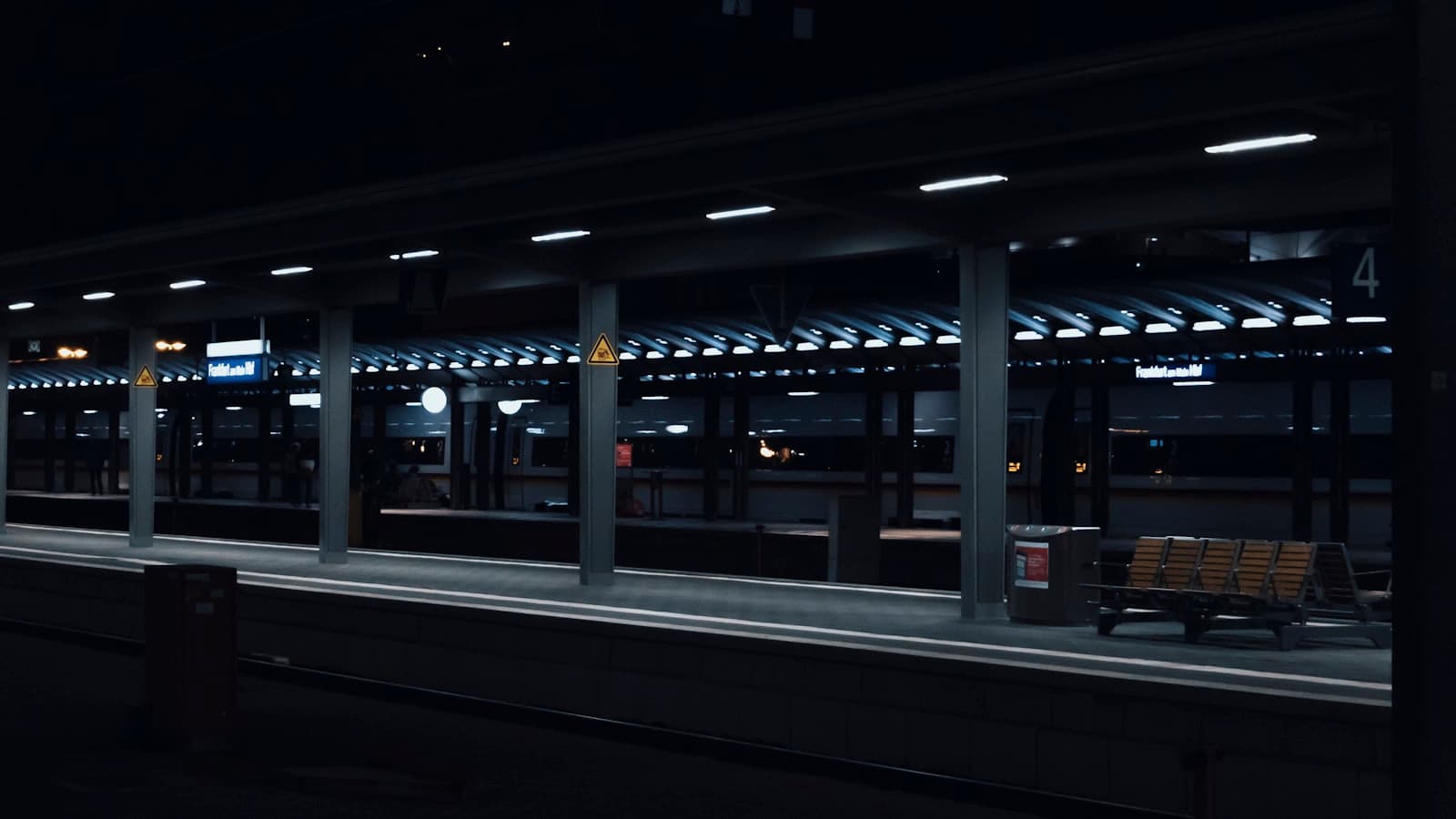Francfort — a train station at night with a bench in the foreground