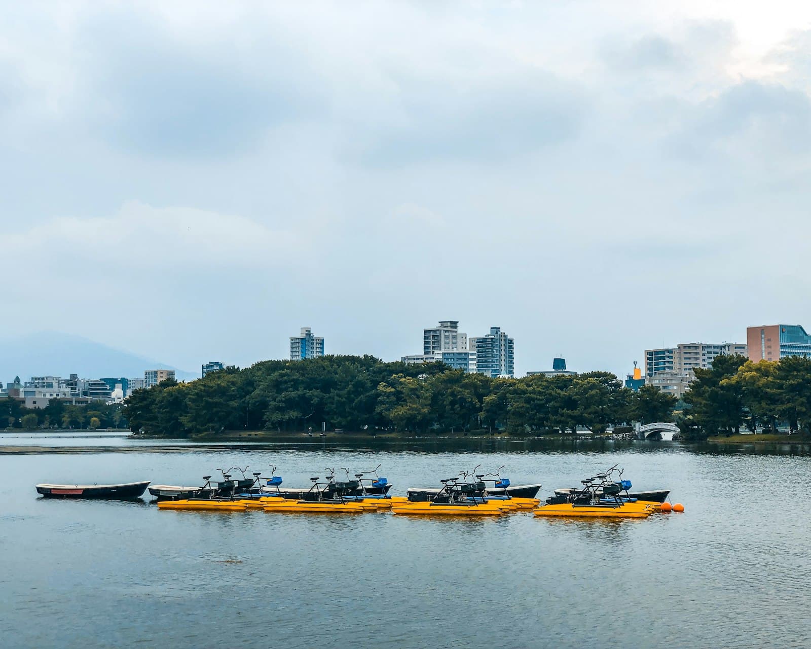 Fukuoka — yellow and black boat on water near city buildings during daytime