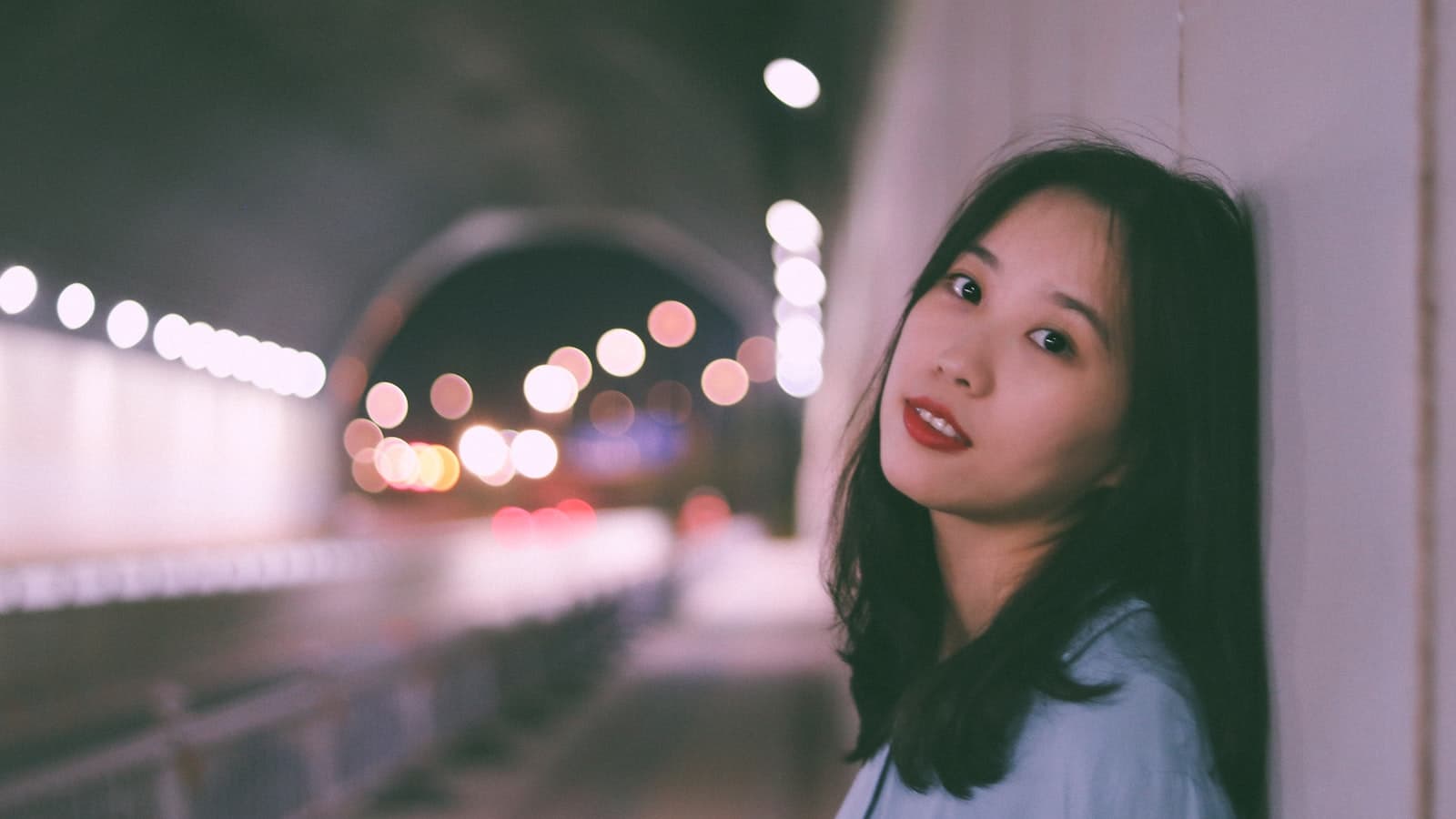 Ganzhou — a woman leaning against a wall in a tunnel