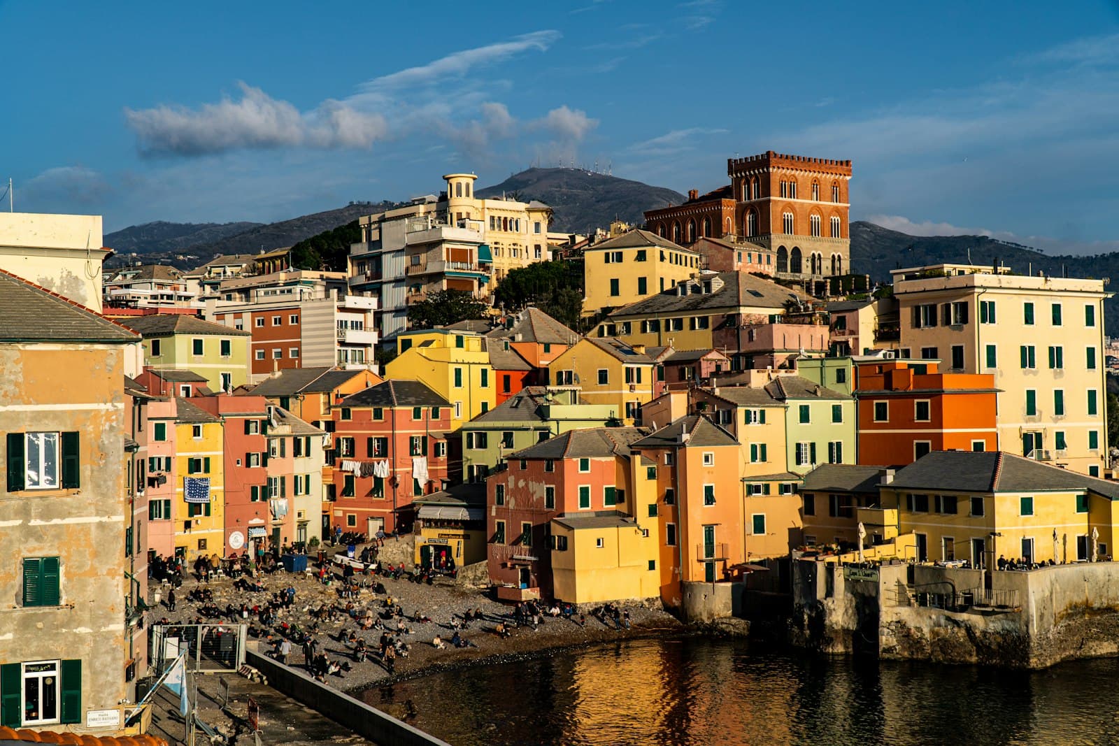 Genoa — brown and white concrete buildings beside river under blue sky during daytime