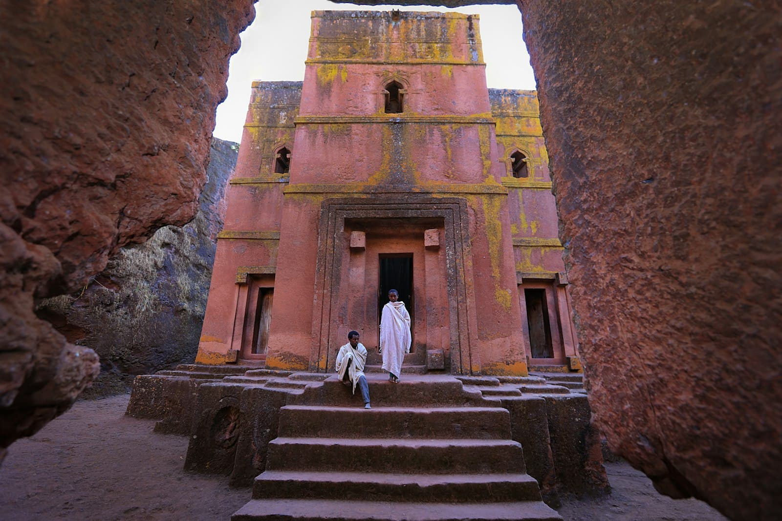 Gondar — person in white dress in front of pink building