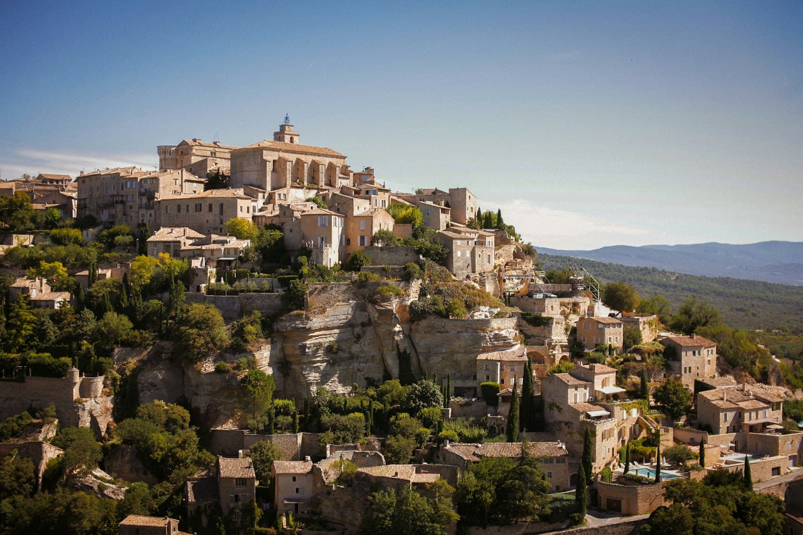 Gordes — a village on top of a hill surrounded by trees