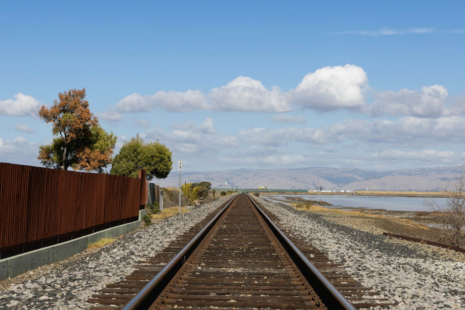 Green Bay — A train track with a fence and a body of water in the background