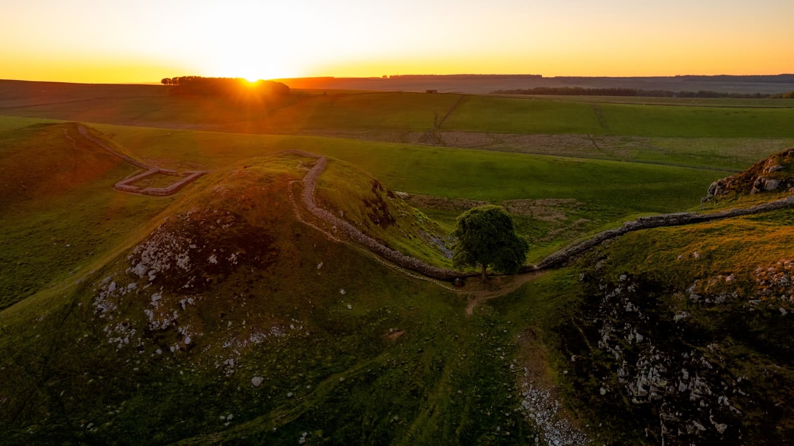Hadrian's Wall — the sun is setting over a green field