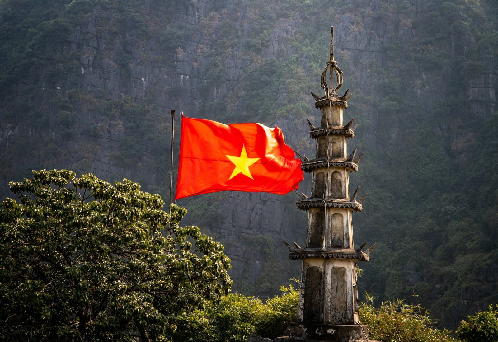 Hải Phòng — A red and yellow flag flying in front of a mountain