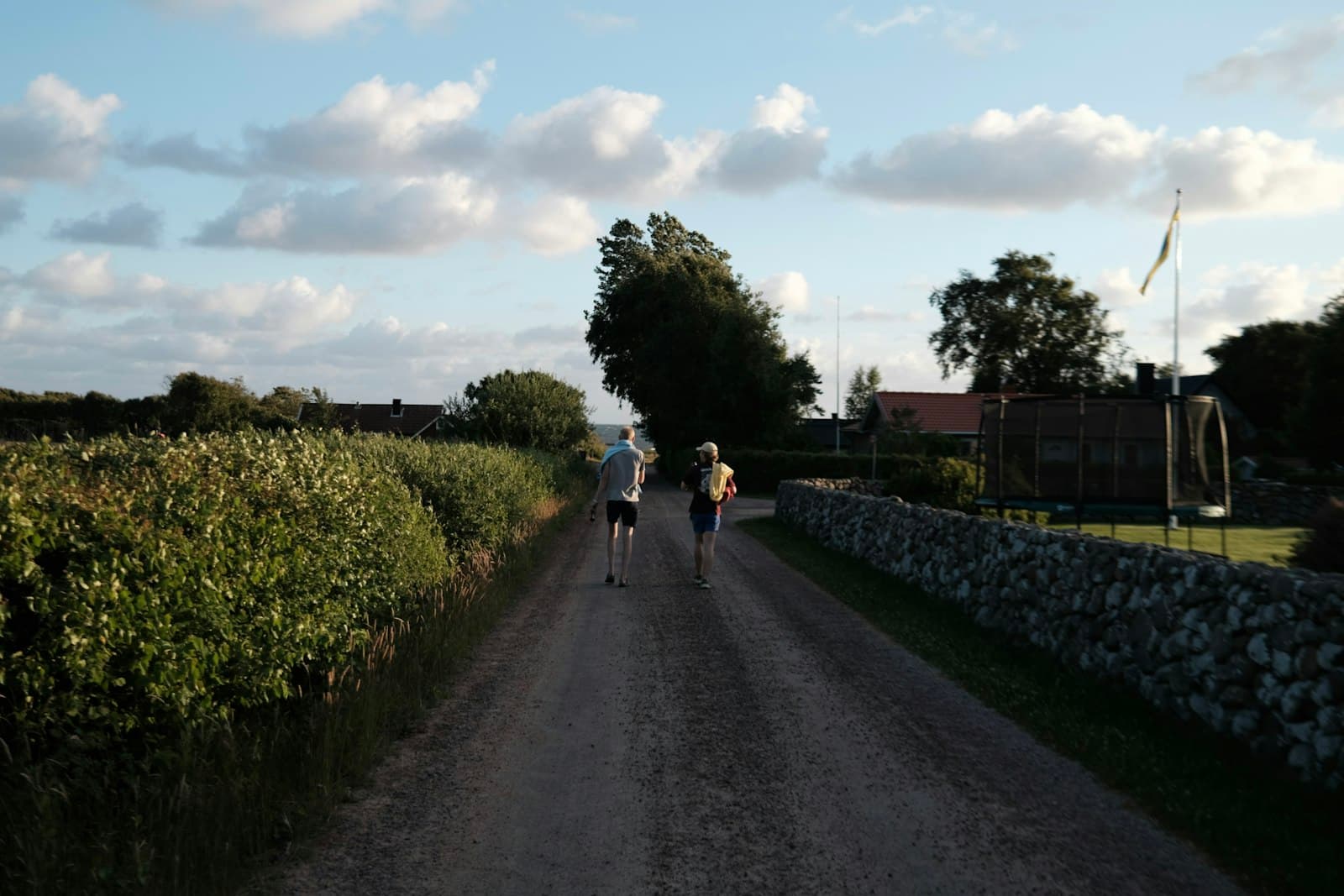 Halmstad — a couple people riding bikes on a path with bushes and trees