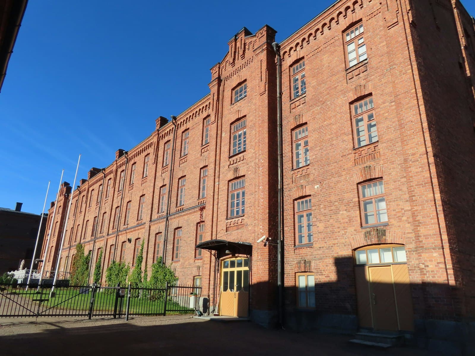 Hämeenlinna — A large brick building with a gate in front of it