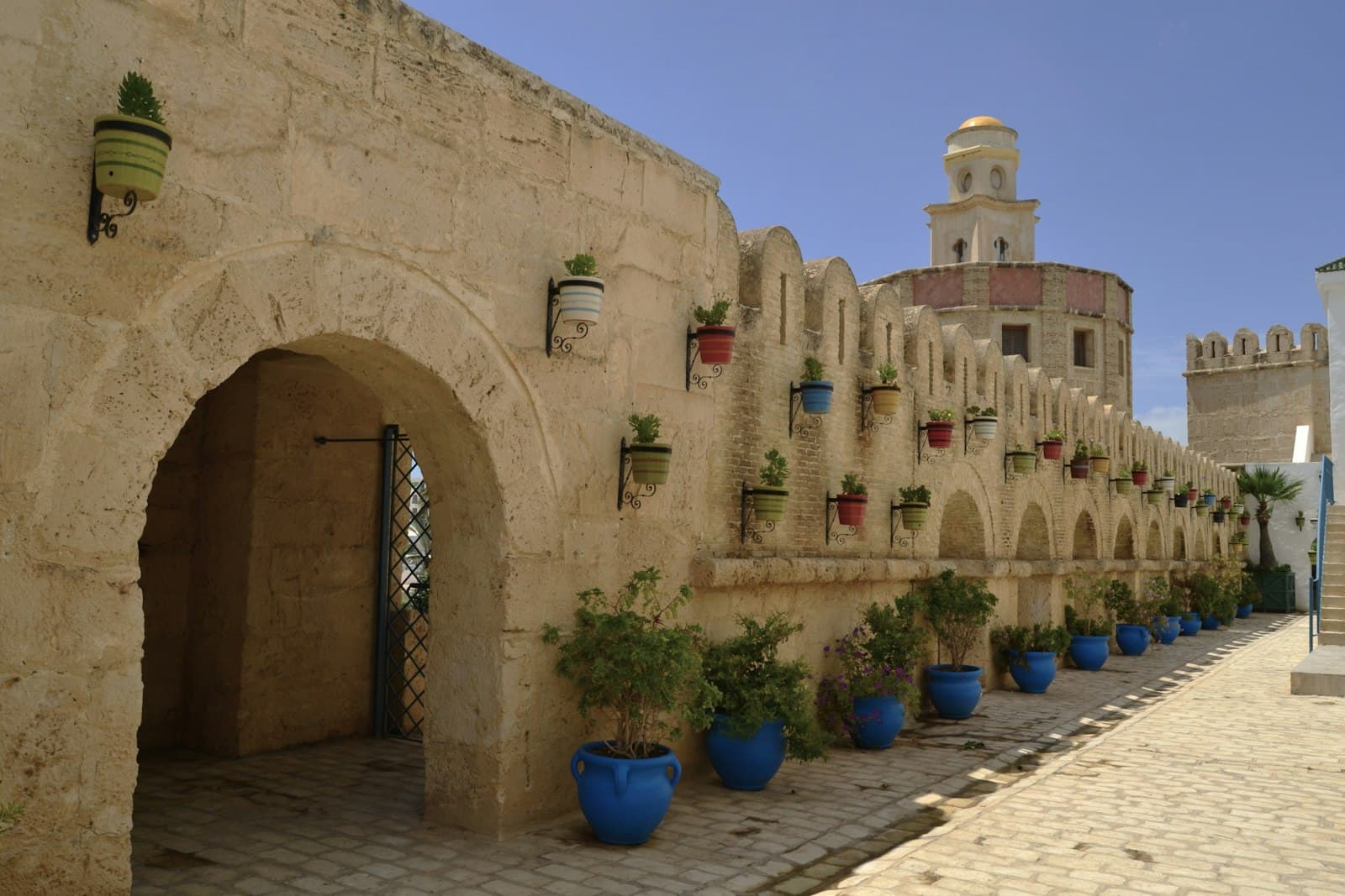 Hammamet — A stone building with blue potted plants in front of it