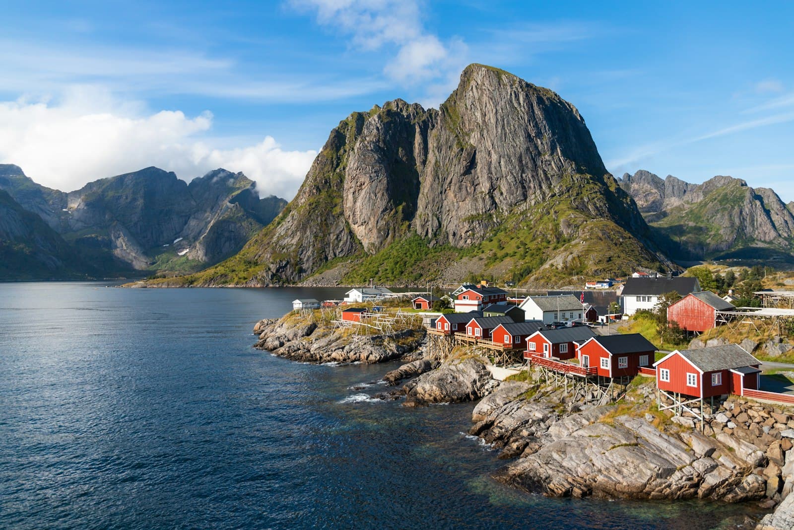 Hammerfest — a group of houses by a body of water with mountains in the background with Lofoten in the background