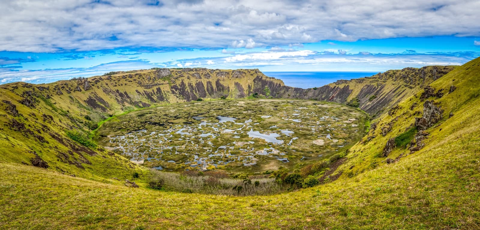 Hanga Roa — green grass field and mountain under blue sky during daytime