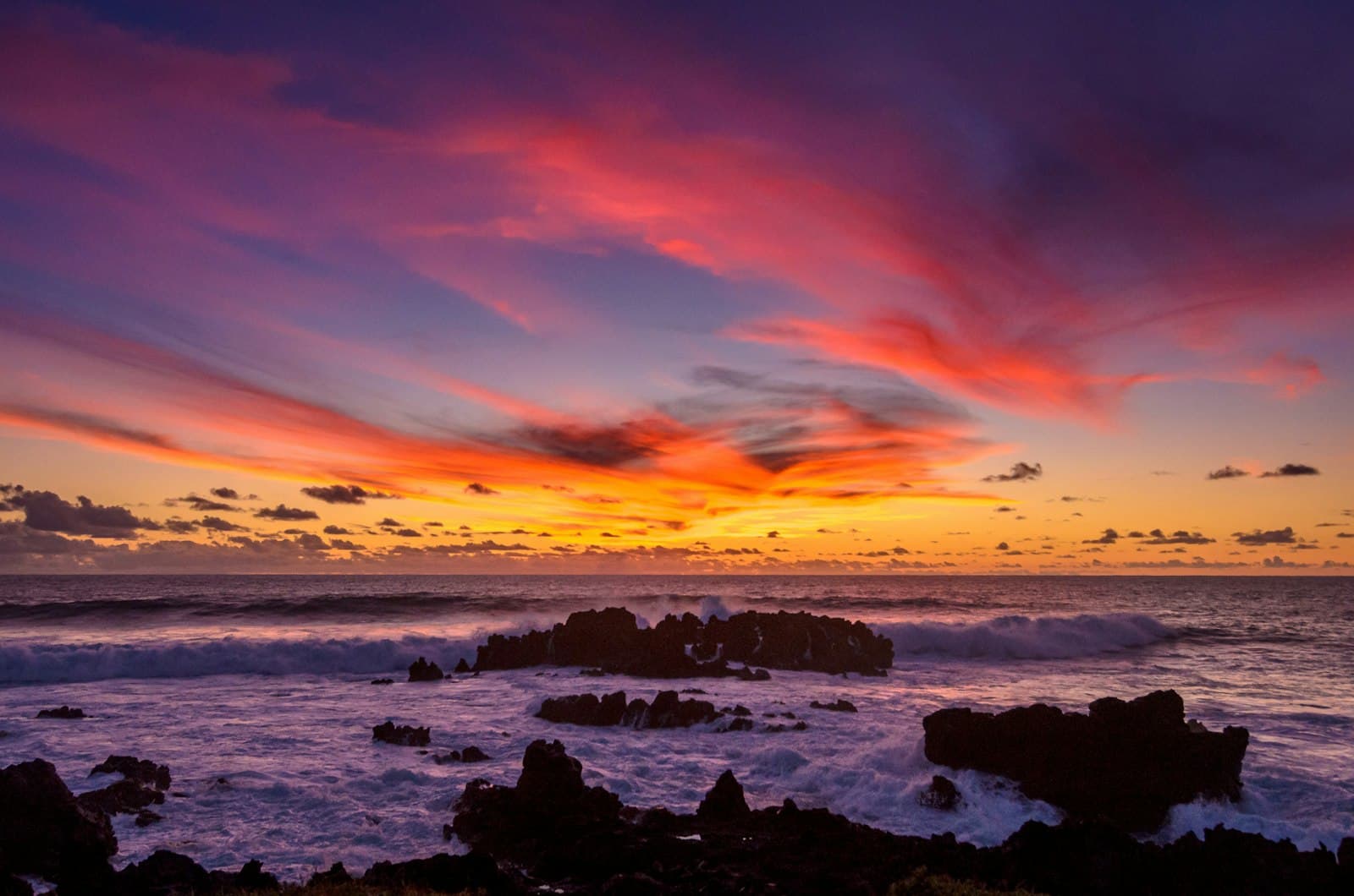 Hanga Roa — ocean waves crashing on rocks during sunset