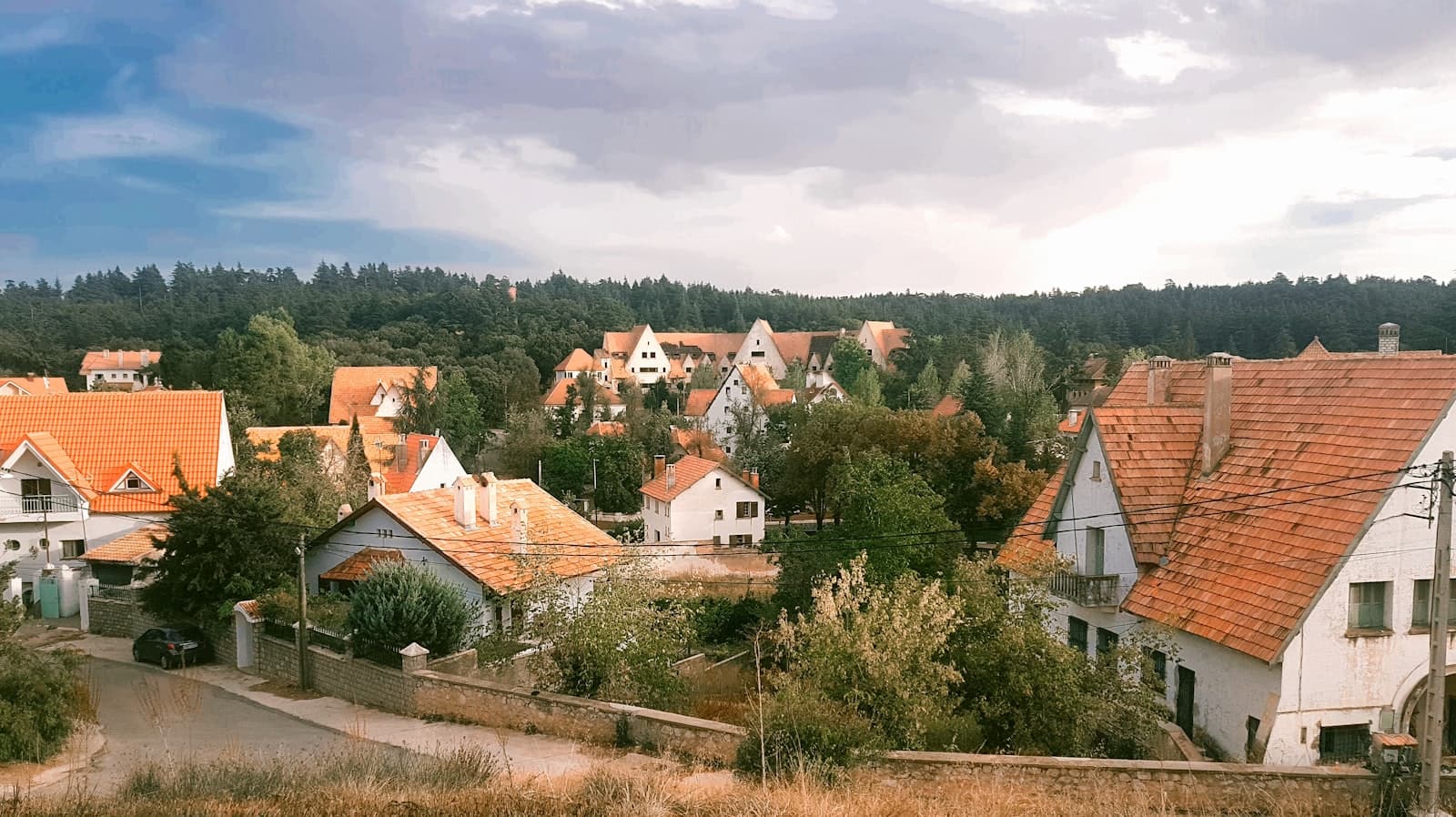 Ifrane — white and brown concrete house surrounded by green trees under white clouds during daytime