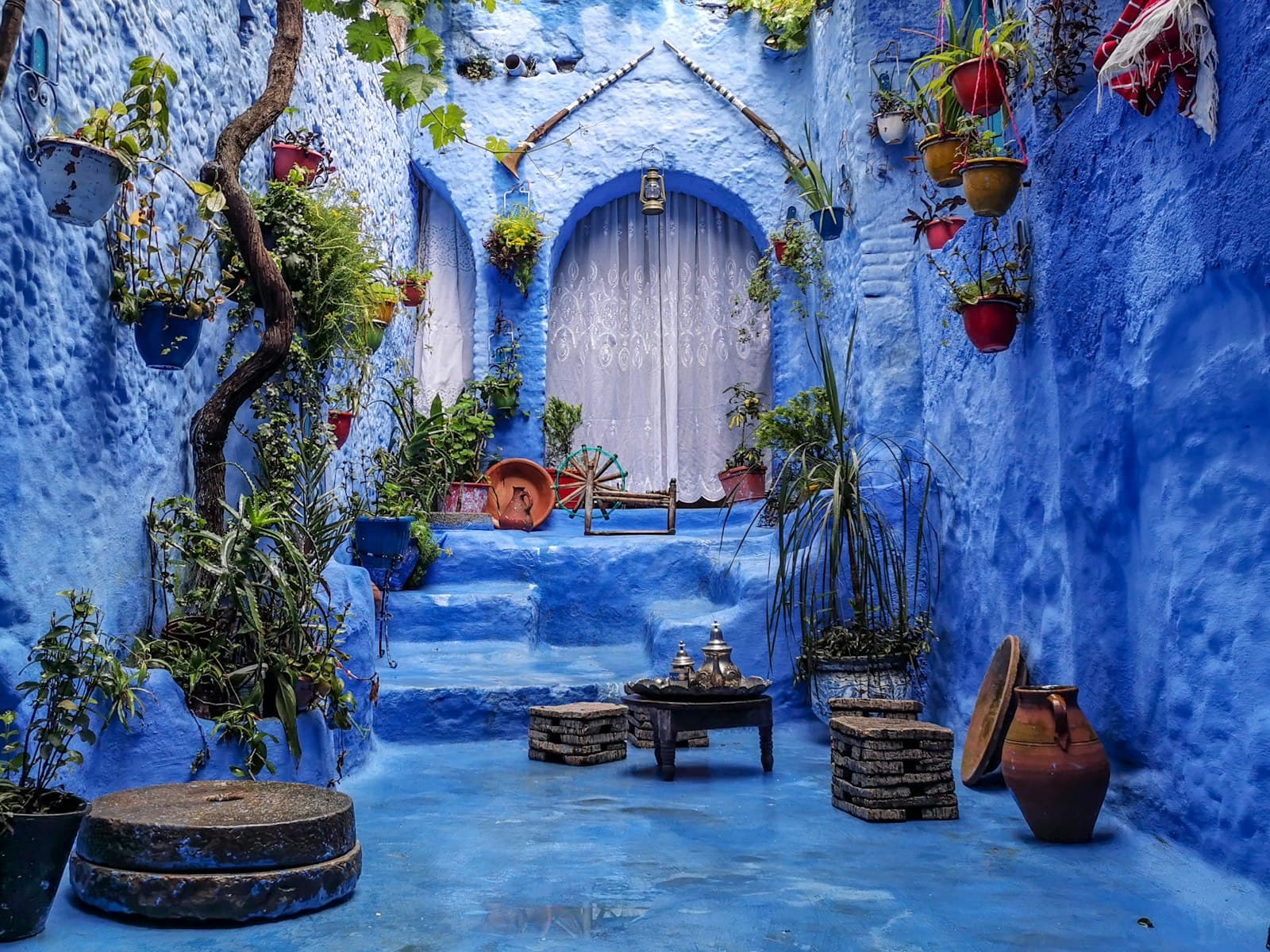 Imlil — a blue alley with potted plants and a bench