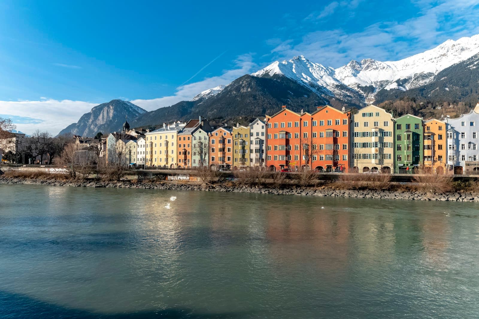 Innsbruck — a river running through a city with mountains in the background