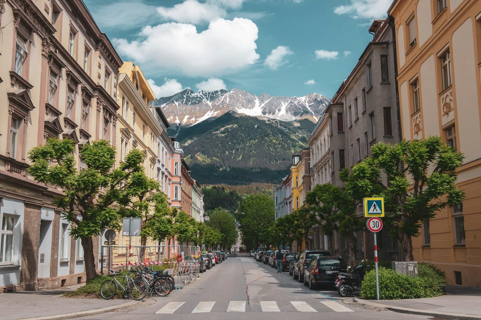 Innsbruck — different vehicles parking near buildings viewing mountain under white and blue skies during daytime