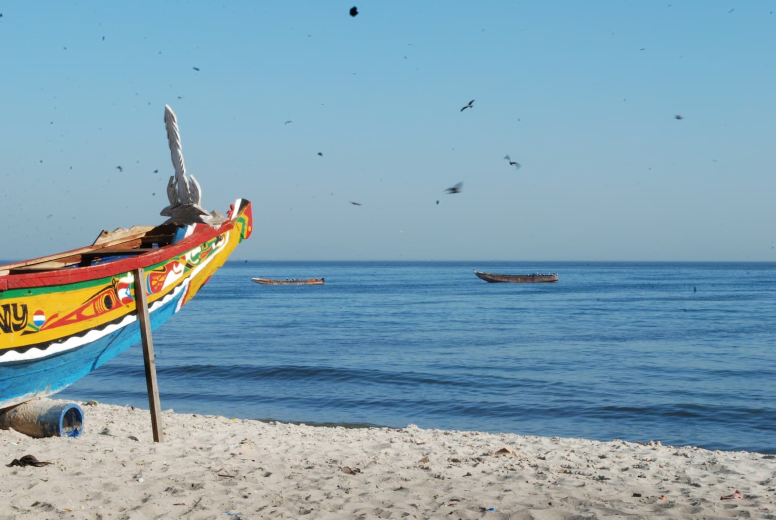 Joal-Fadiouth — a colorful boat sitting on top of a sandy beach