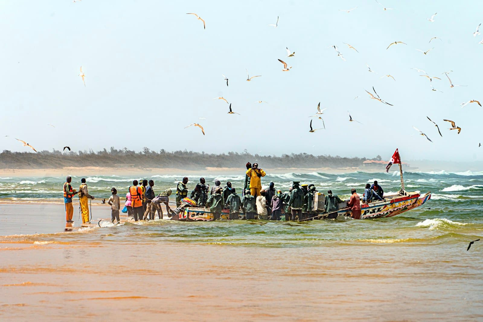 Joal-Fadiouth — A group of people standing on top of a boat in the ocean