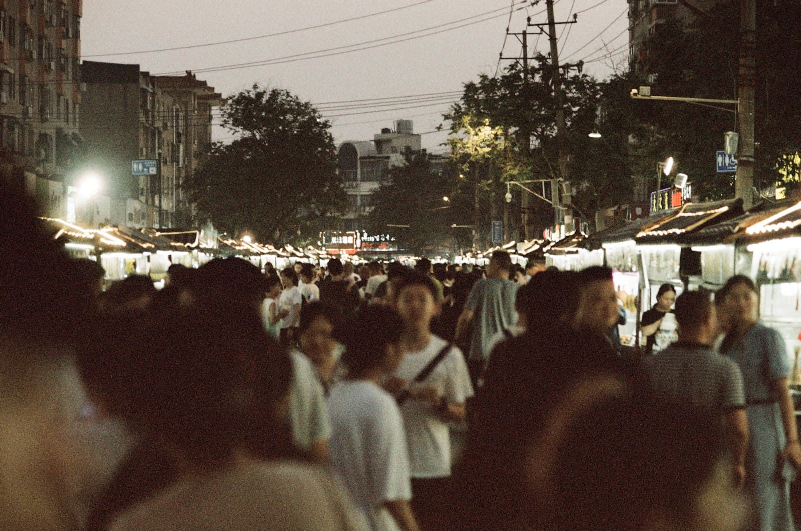 Kaifeng — a crowd of people walking down a street at night