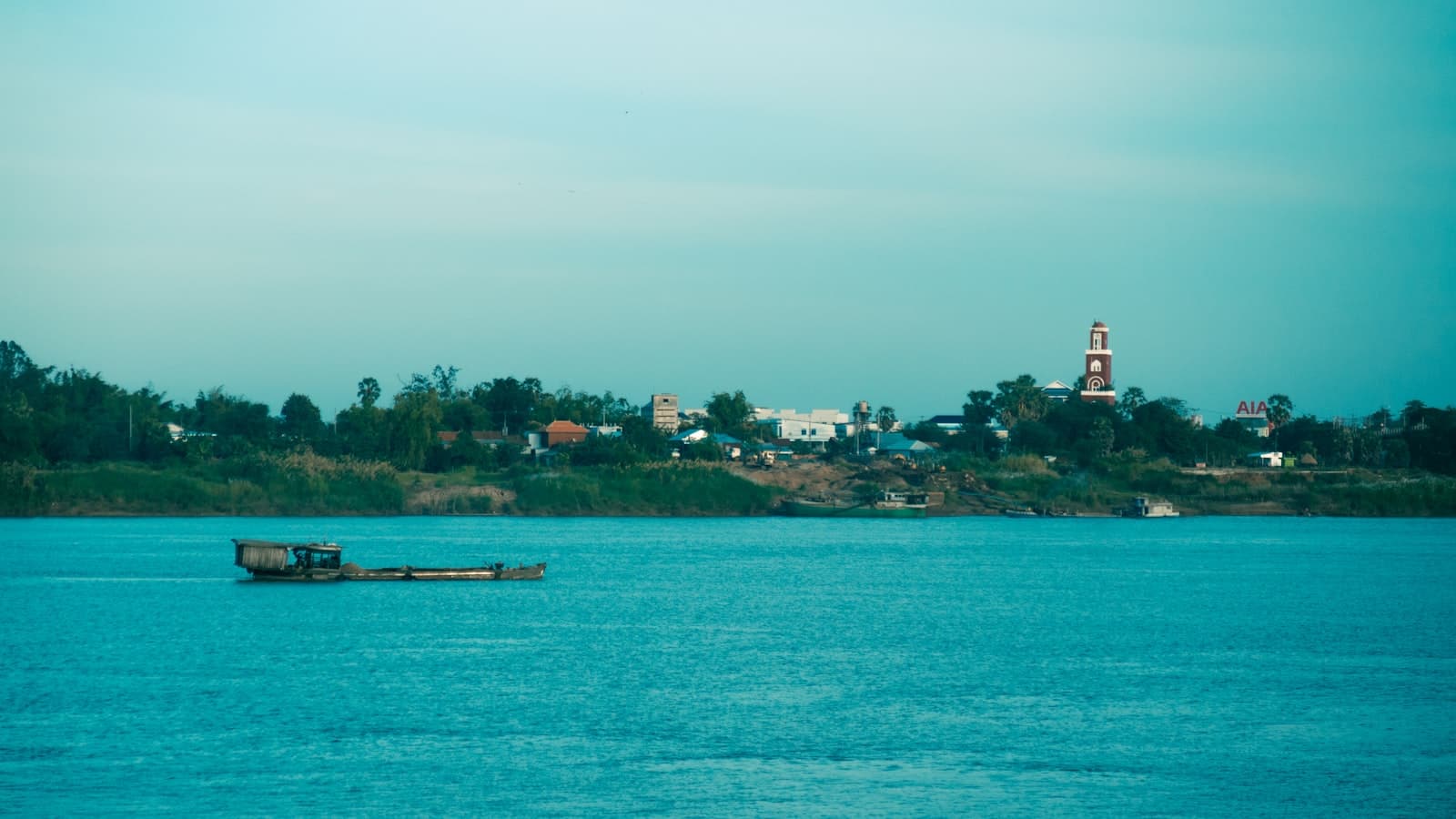 Kampong Cham — a small boat floating on top of a large body of water