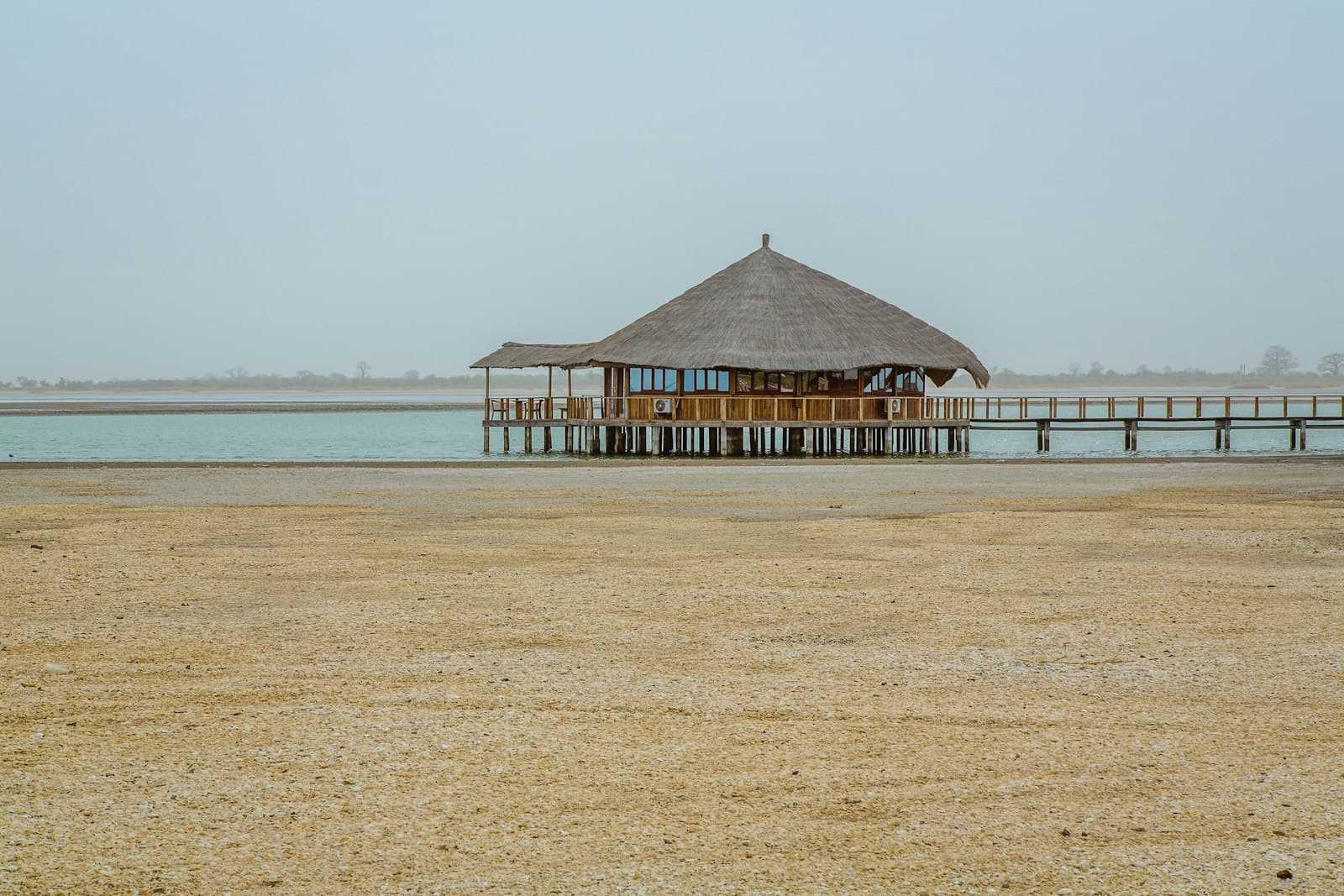 Kaolack — brown wooden hut above water near shore at daytime