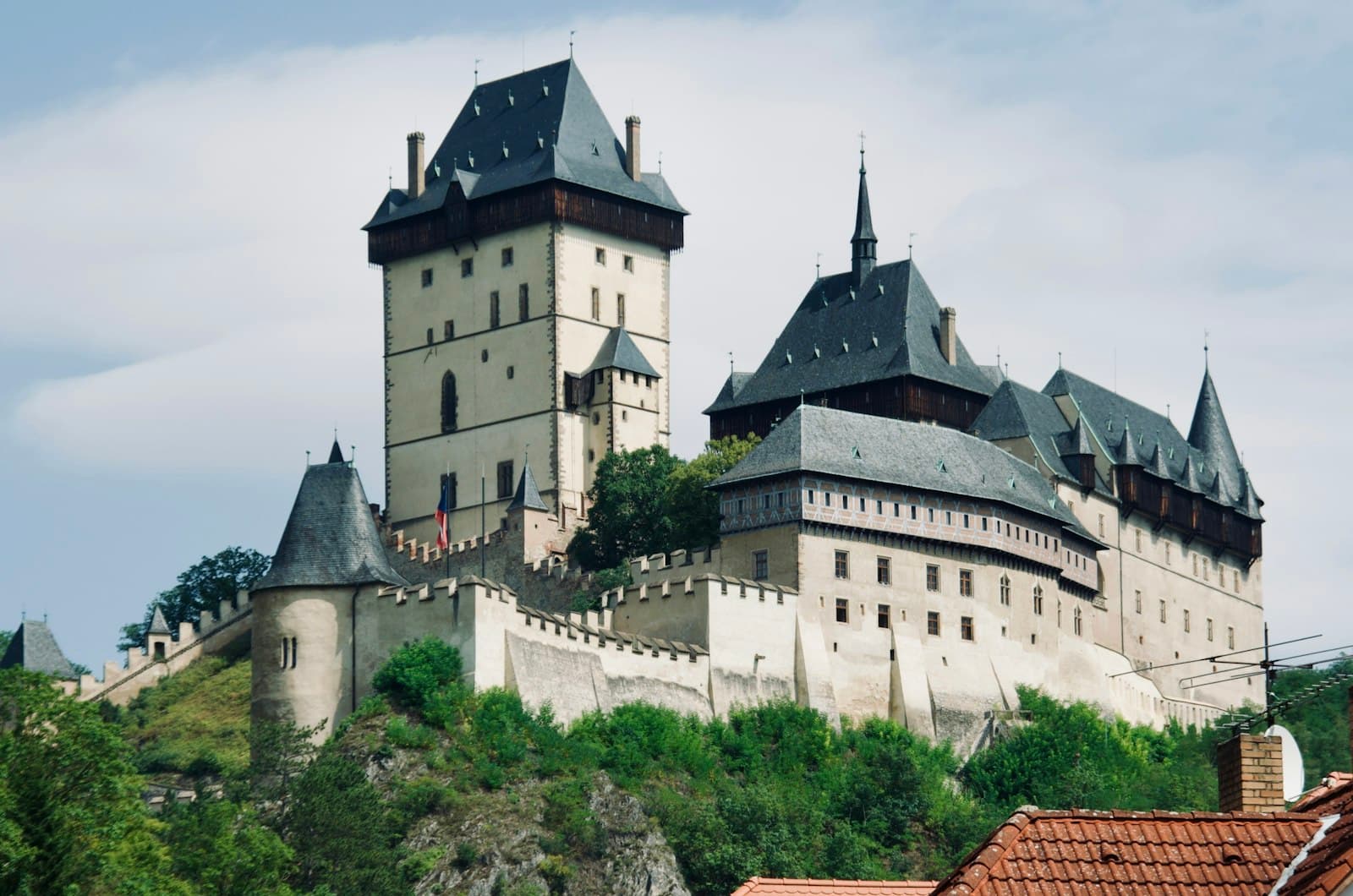 Karlštejn — A castle on top of a hill surrounded by trees