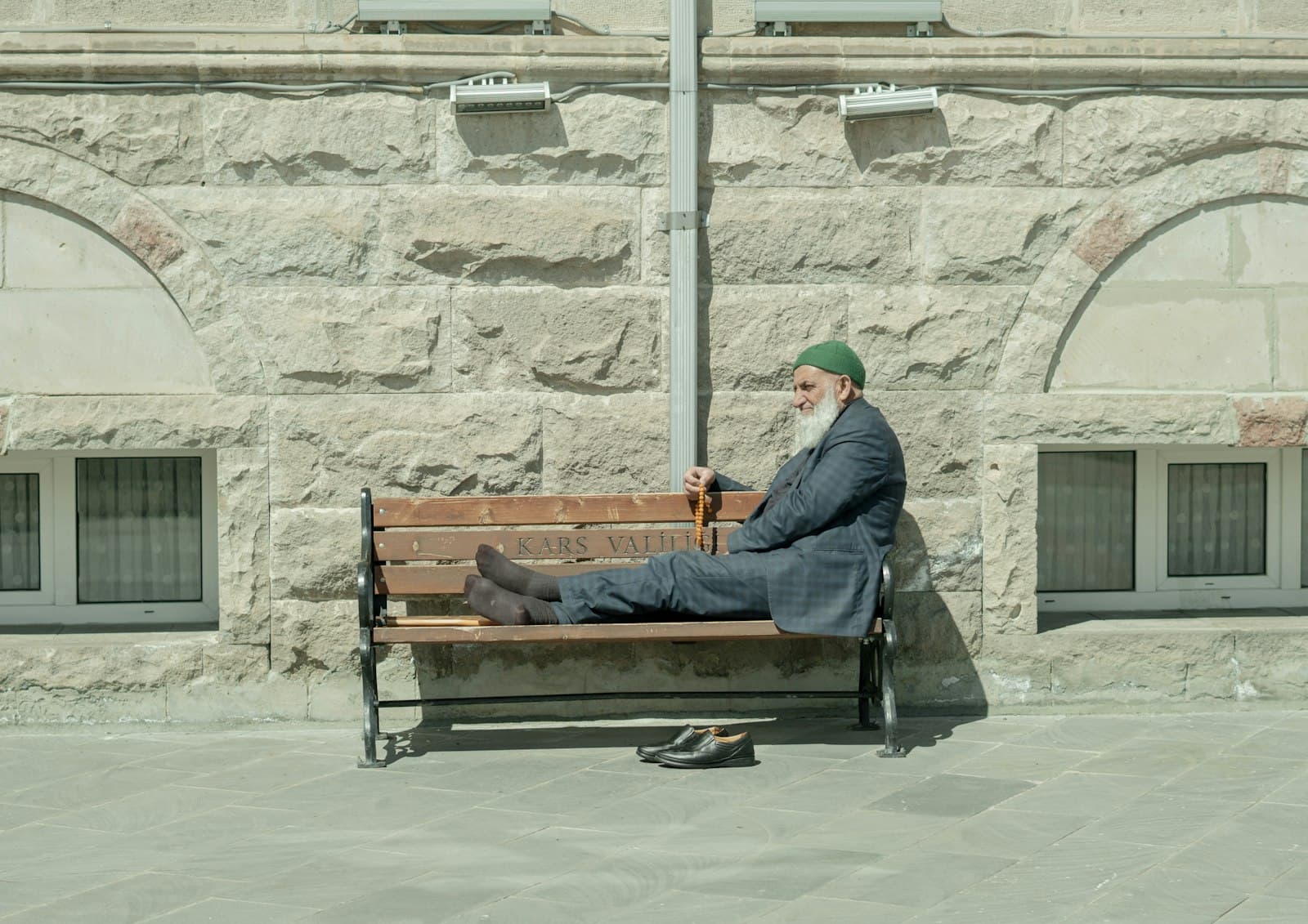 Kars — man in black jacket sitting on brown wooden bench