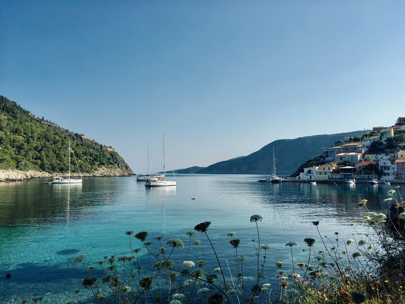 Kavala — white boat on water near mountain during daytime