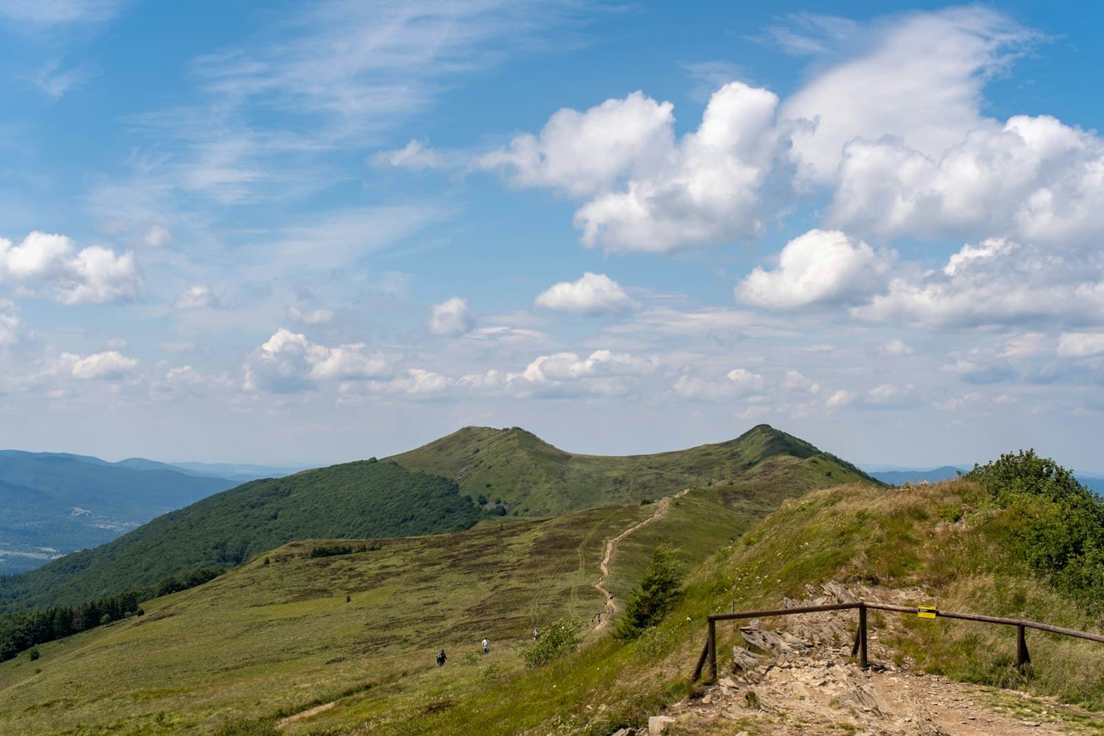 Kazimierz Bieszczady — Green rolling hills under a cloudy blue sky