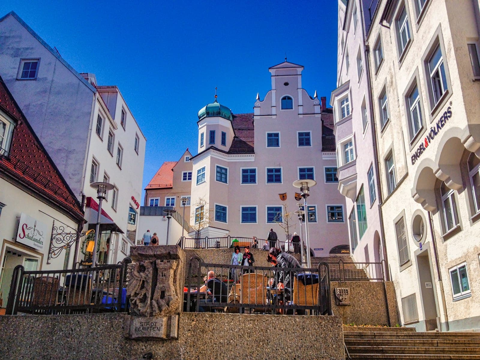 Kempten — people walking on street near white and brown concrete building during daytime