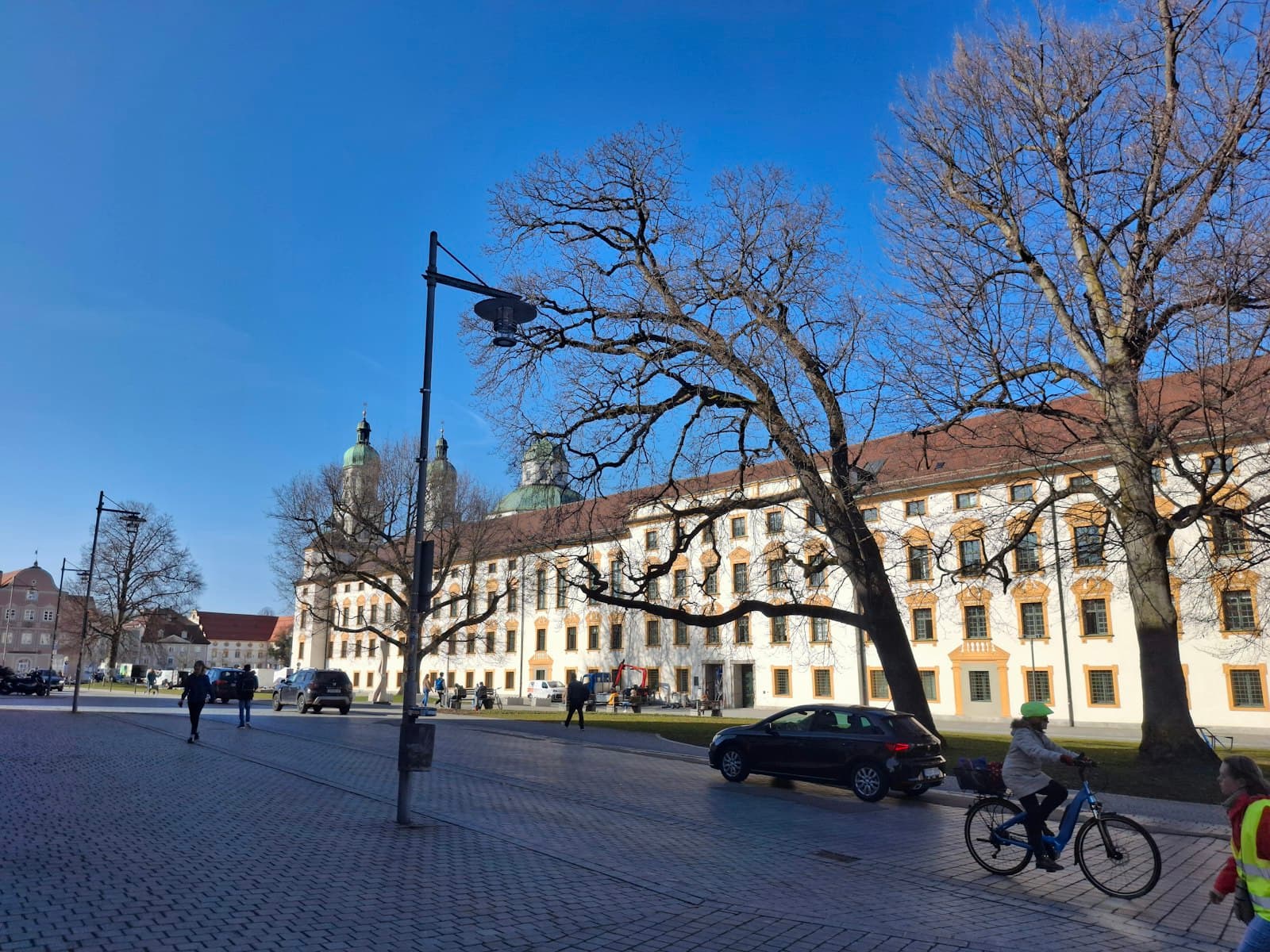 Kempten — Sunny day with people walking and cycling near buildings.
