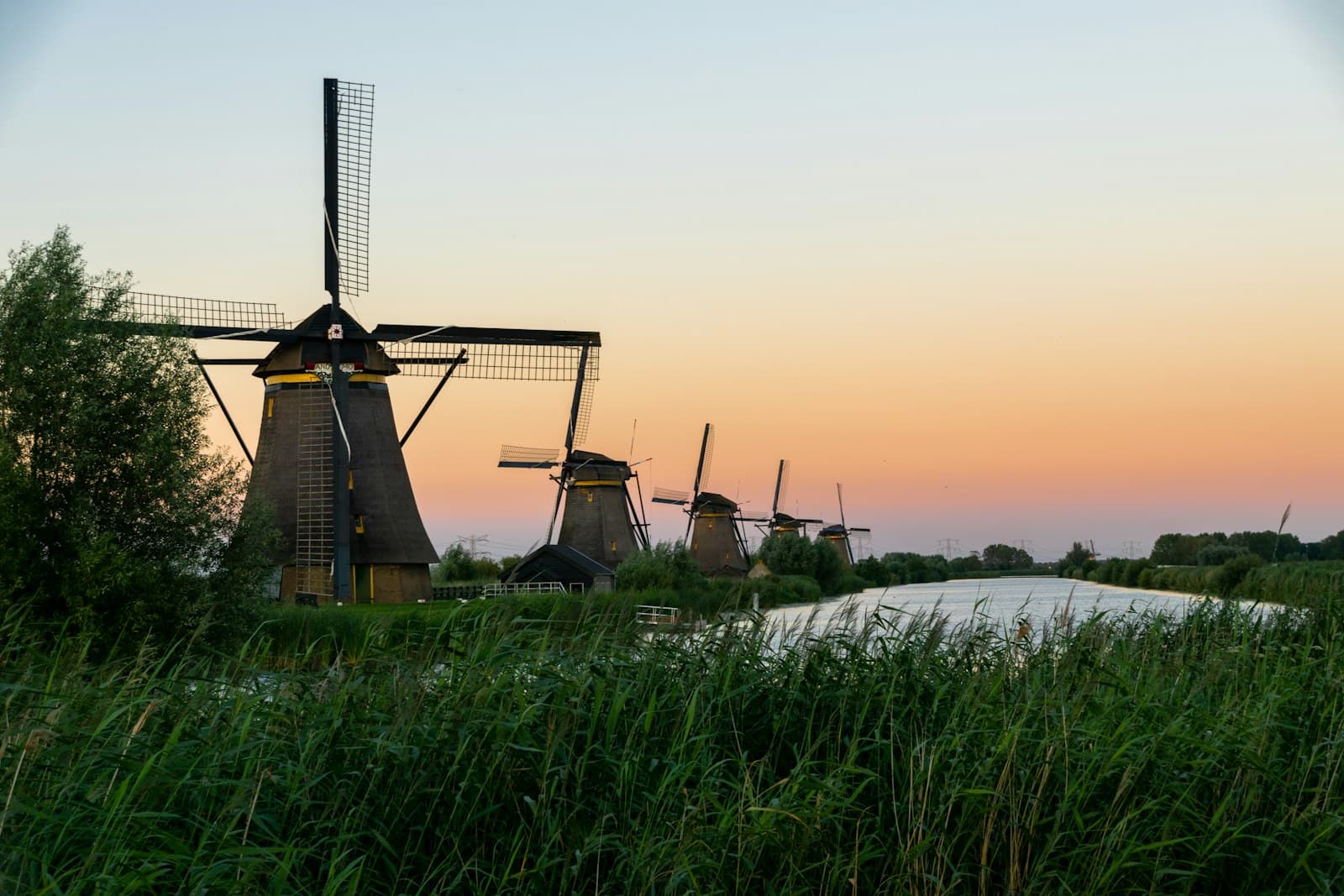 Kinderdijk — green grass field near body of water during sunset
