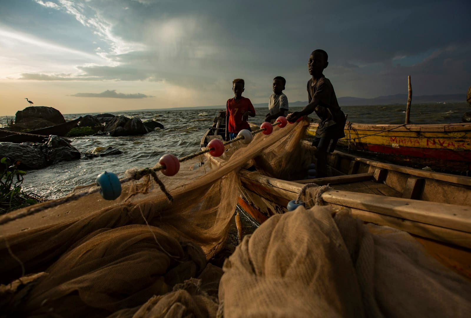 Kisumu — a group of people standing on top of a boat near the ocean