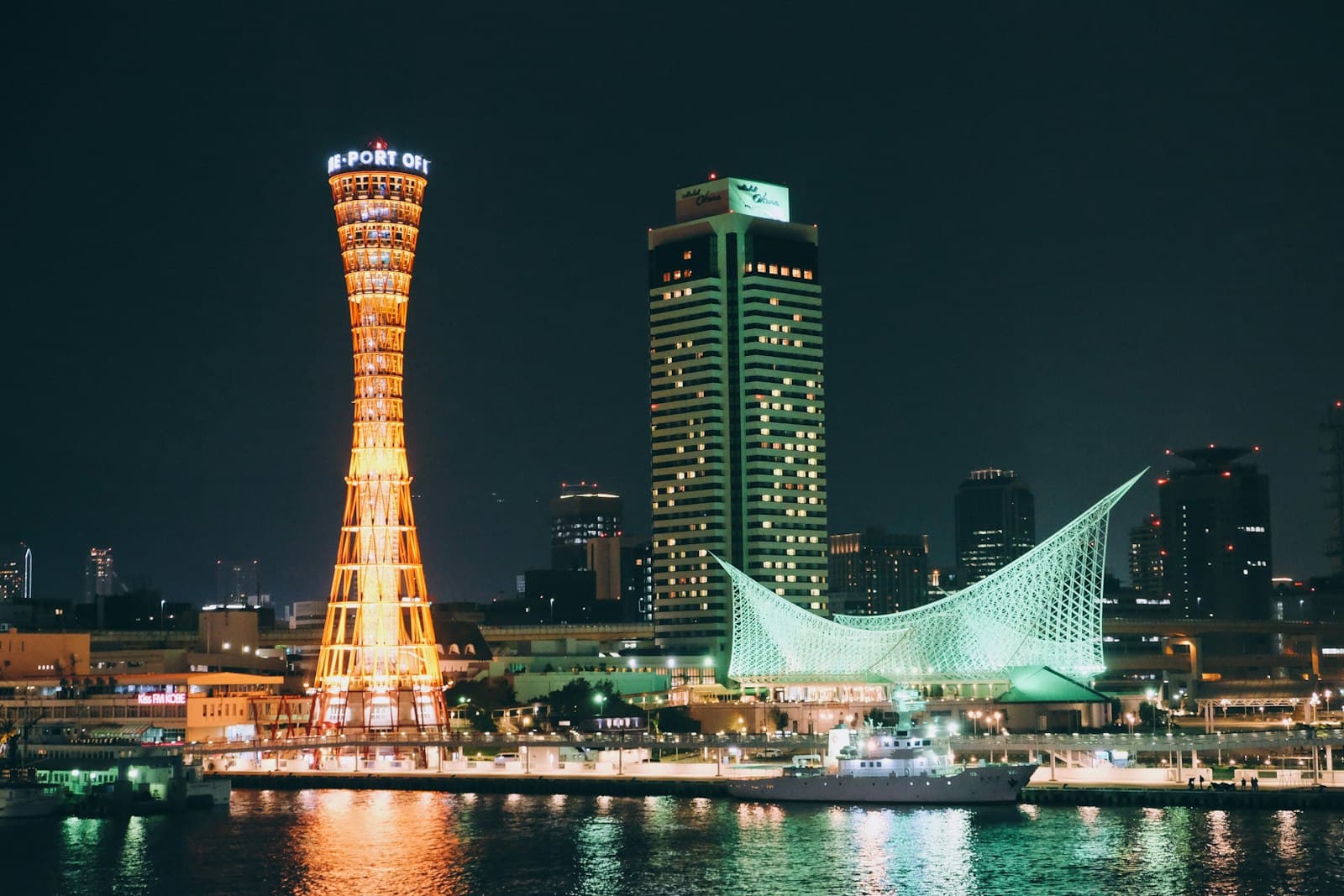 Kobe — lighted high rise building near body of water during night time