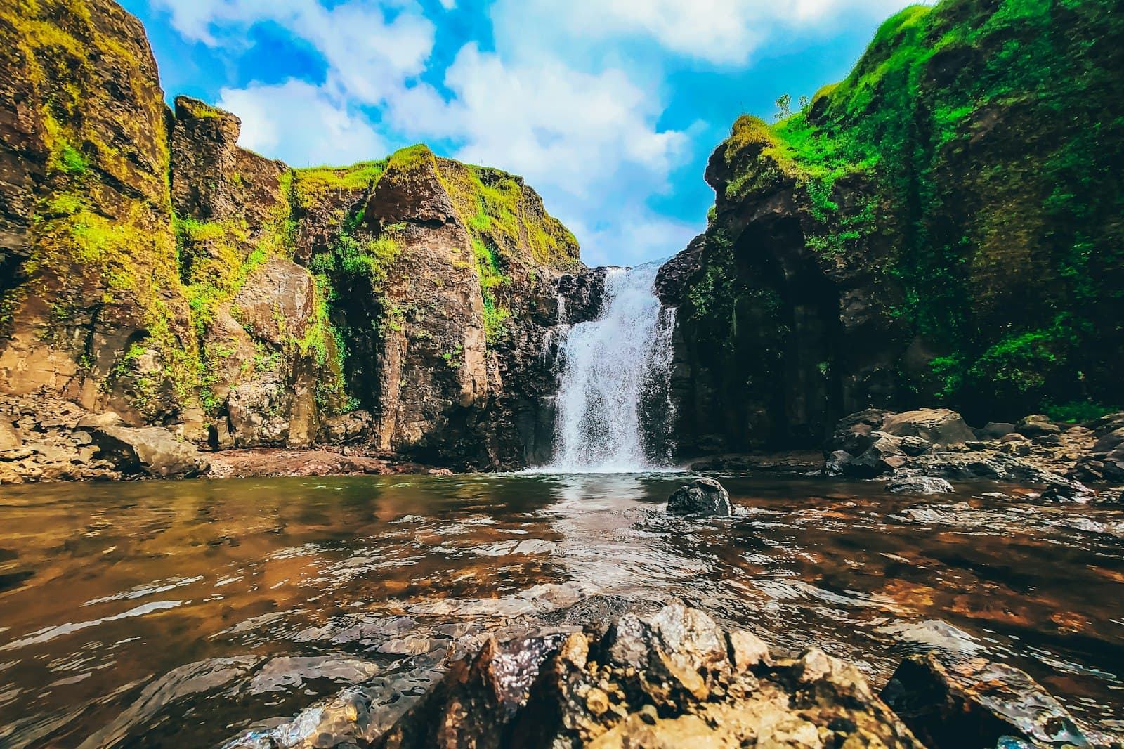 Kolhapur — water falls on rocky mountain under blue sky during daytime