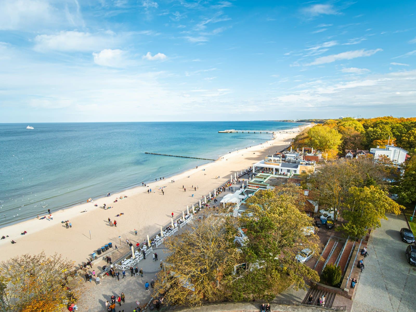 Kołobrzeg — an aerial view of a beach with people walking on it
