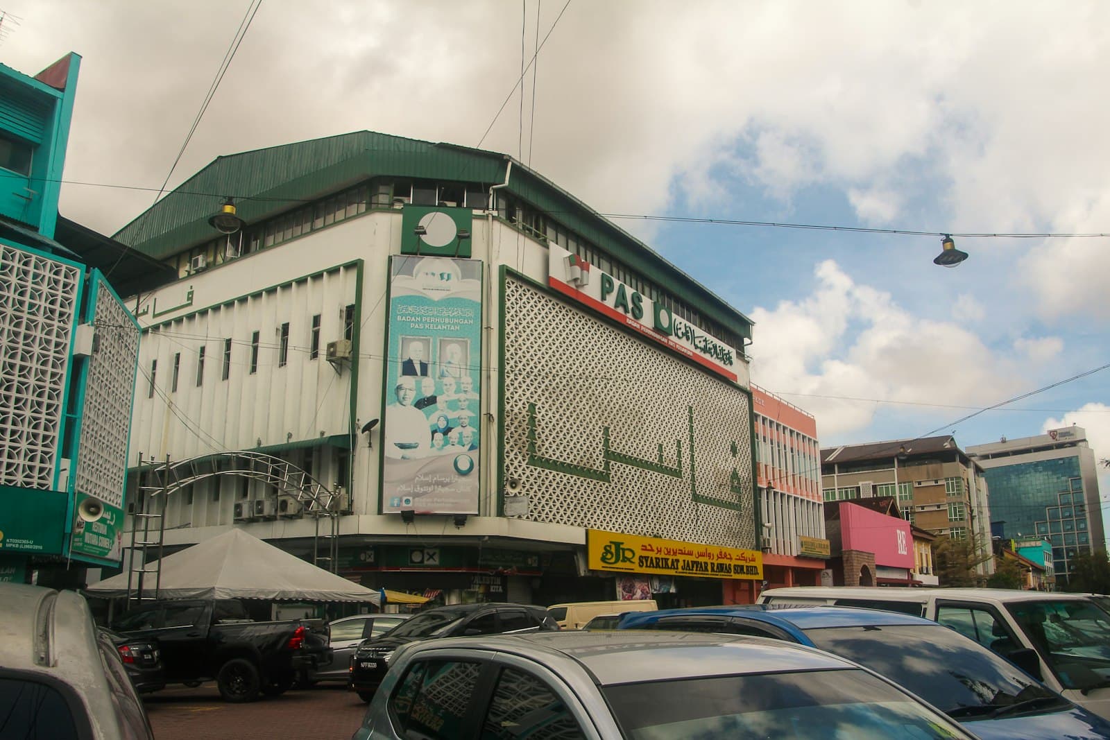 Kota Bharu — a city street filled with lots of traffic next to tall buildings
